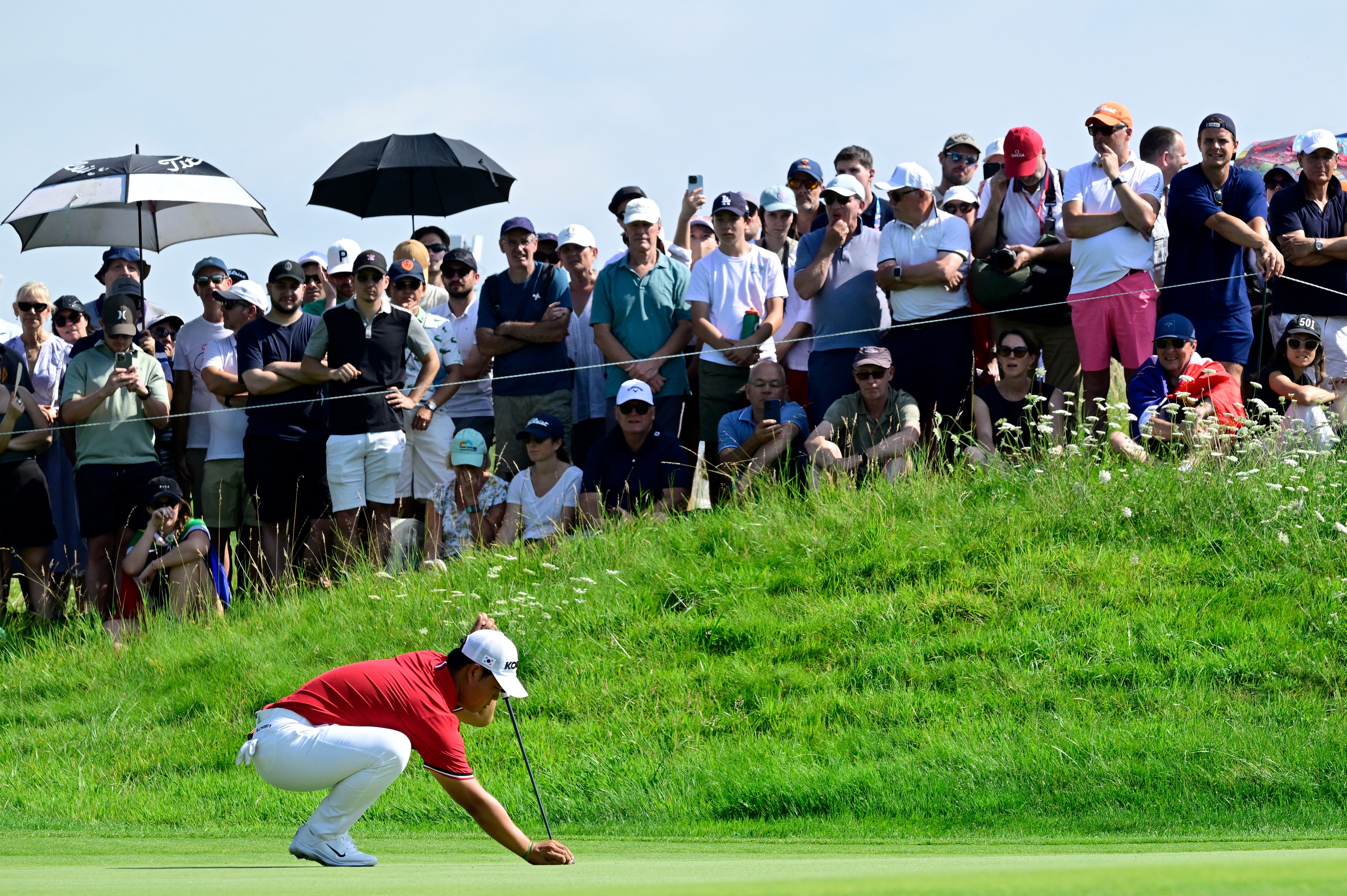 Tom Kim lines up a putt at Le Golf National