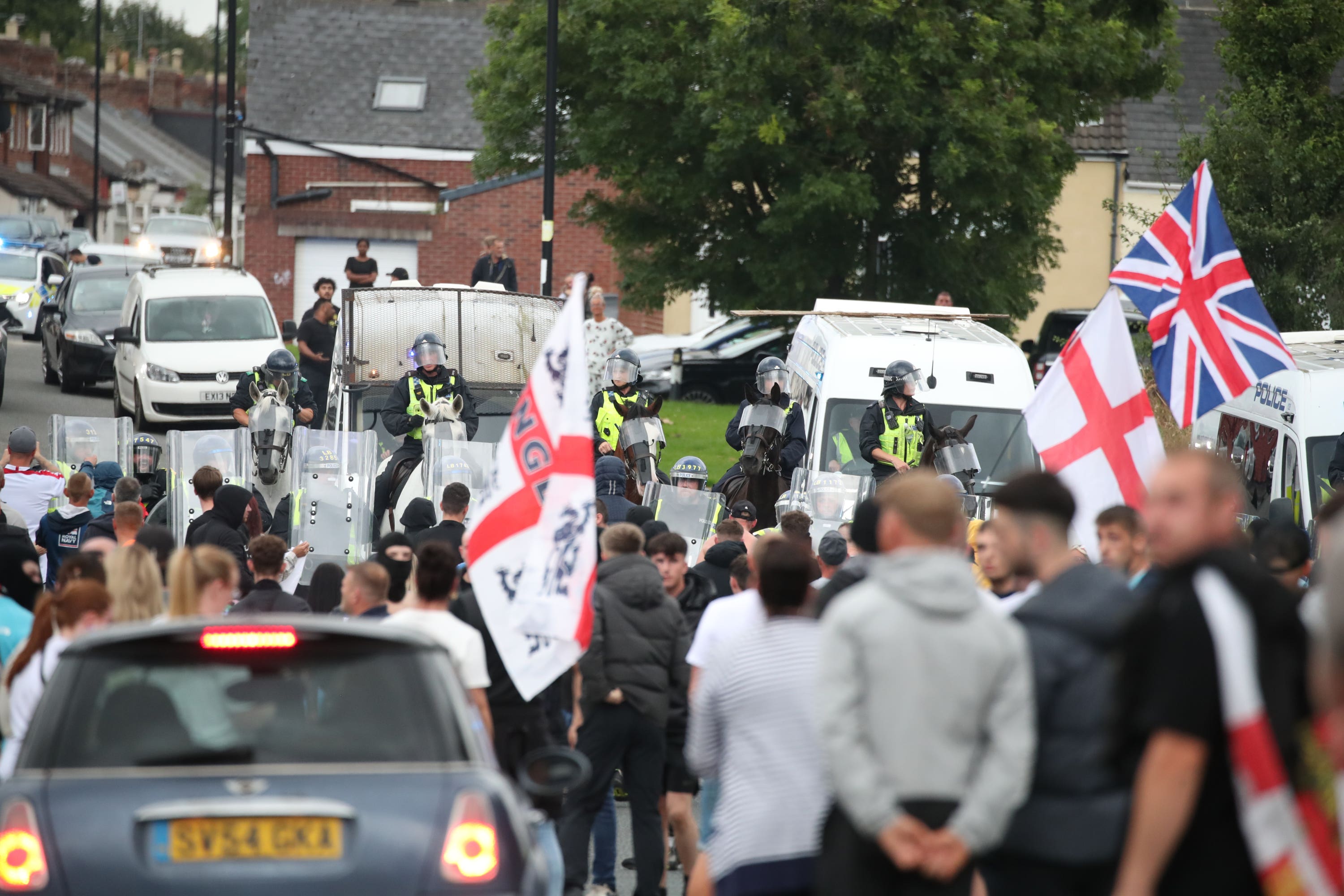 Protesters face off with a line of police and riot vans in Sunderland on Friday