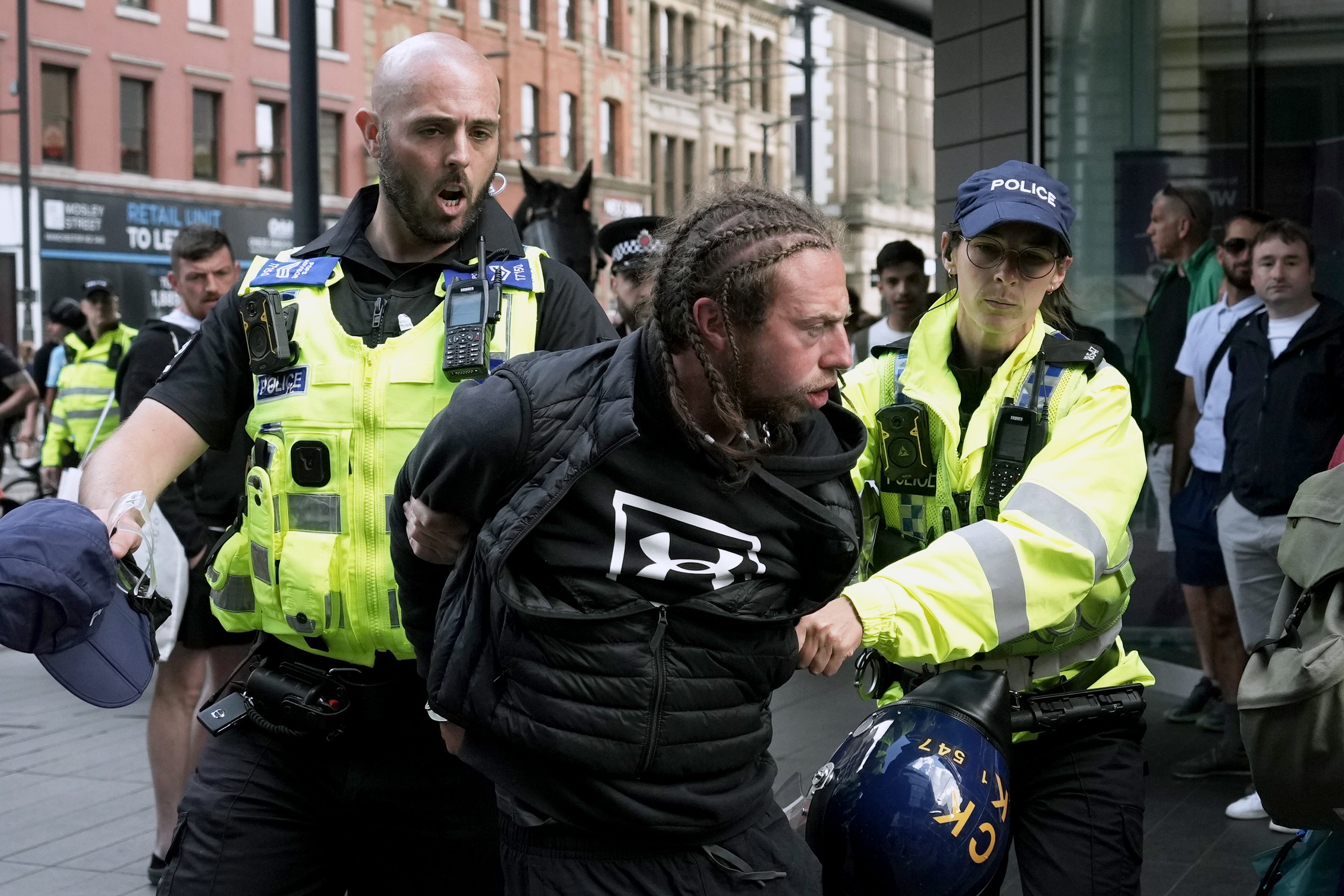 A protestor is detained by the police at Piccadilly Gardens,Manchester, amid fears of more violence across the UK’s major towns and cities