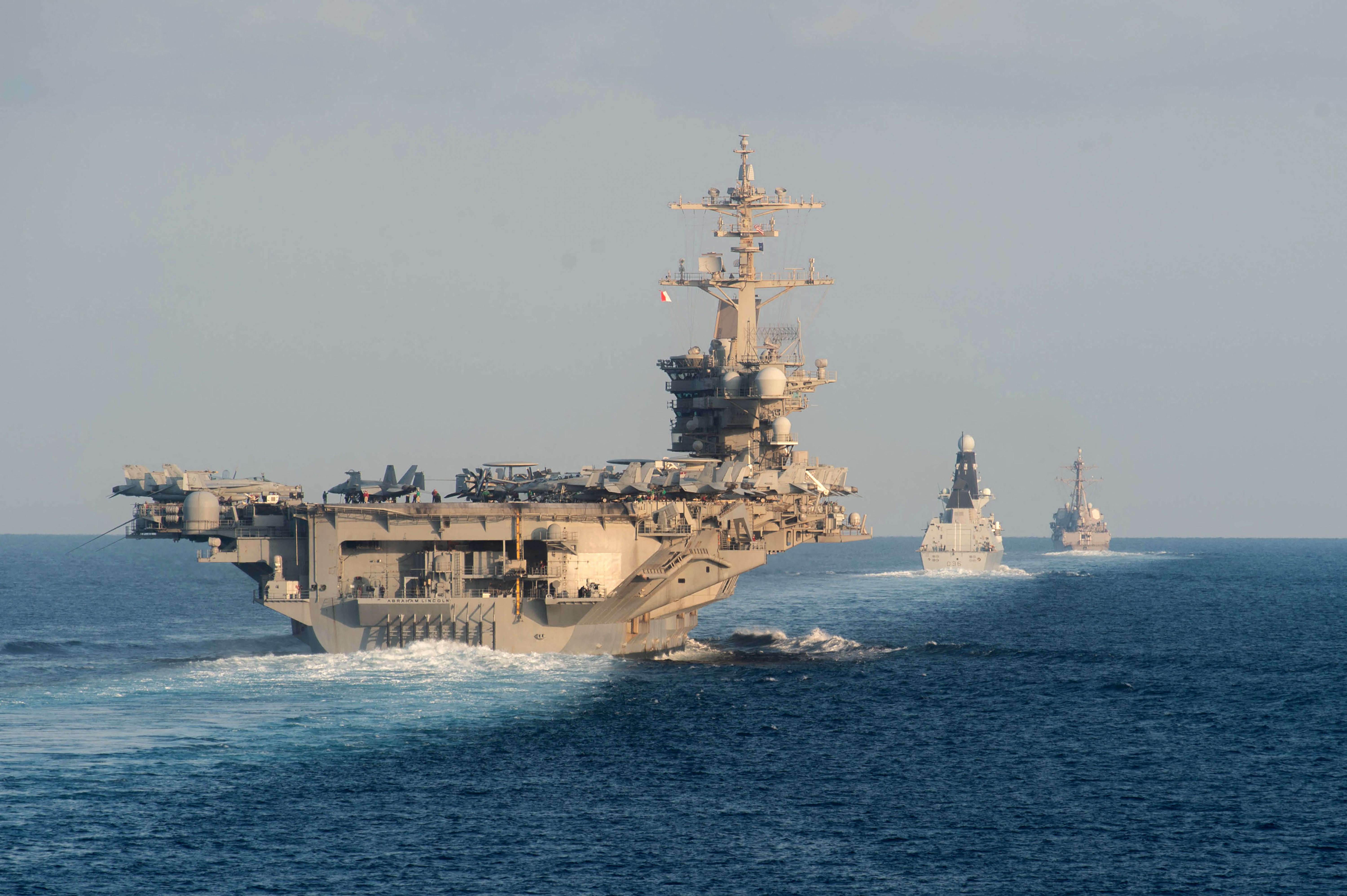 The aircraft carrier USS Abraham Lincoln, left