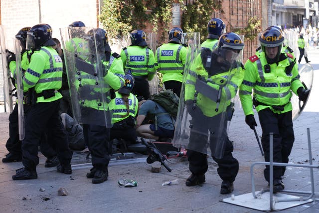 An injured man is attended to during a protest in Liverpool (James Speakman/PA)