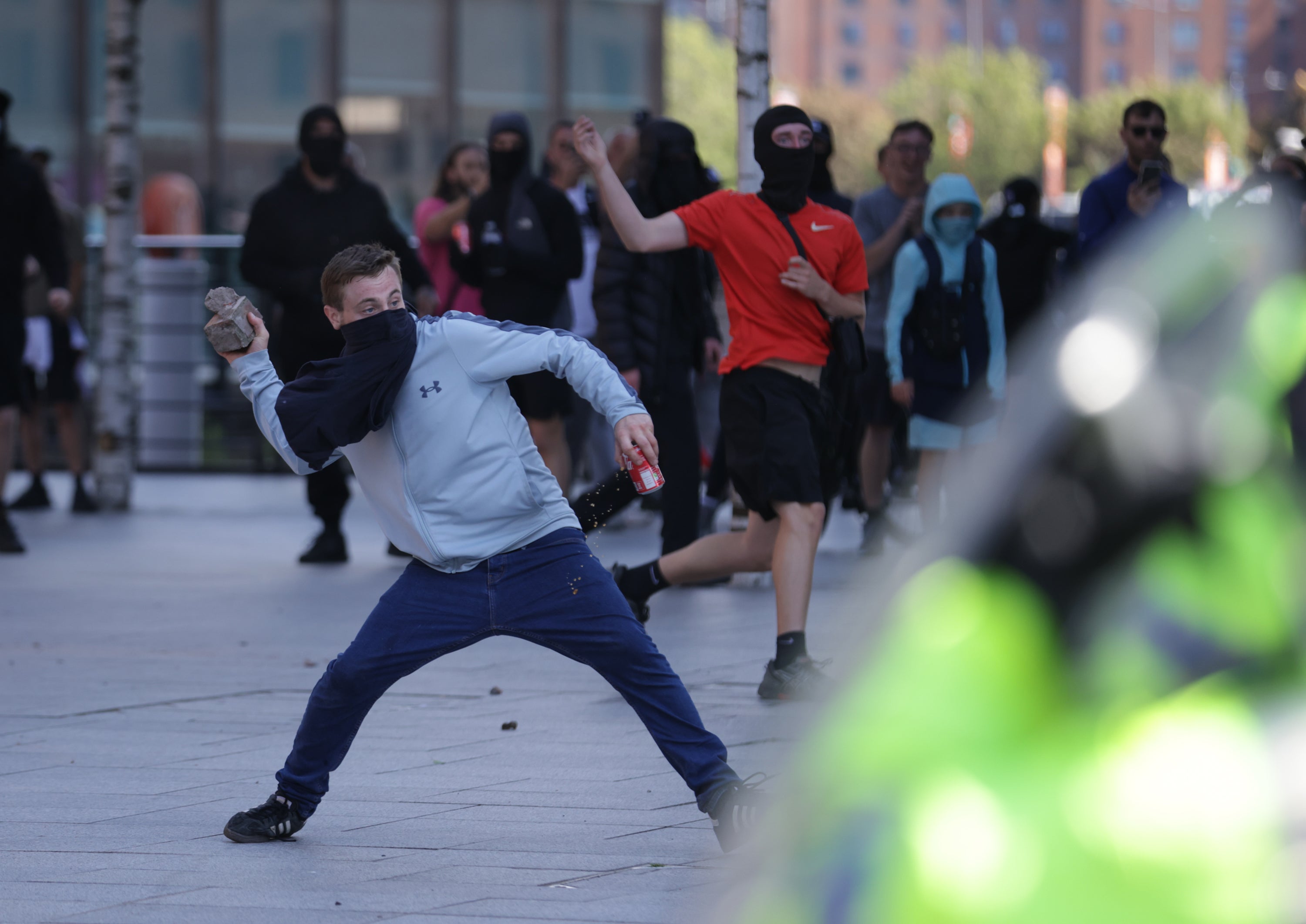 A man throws a brick during a protest in Liverpool (James Speakman/PA)