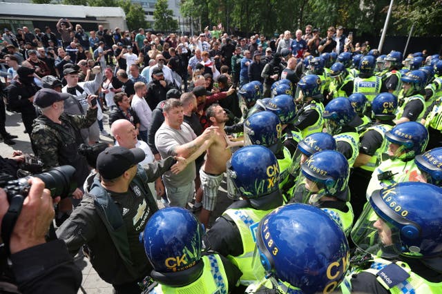 <p>Protesters confront police officers in Manchester</p>
