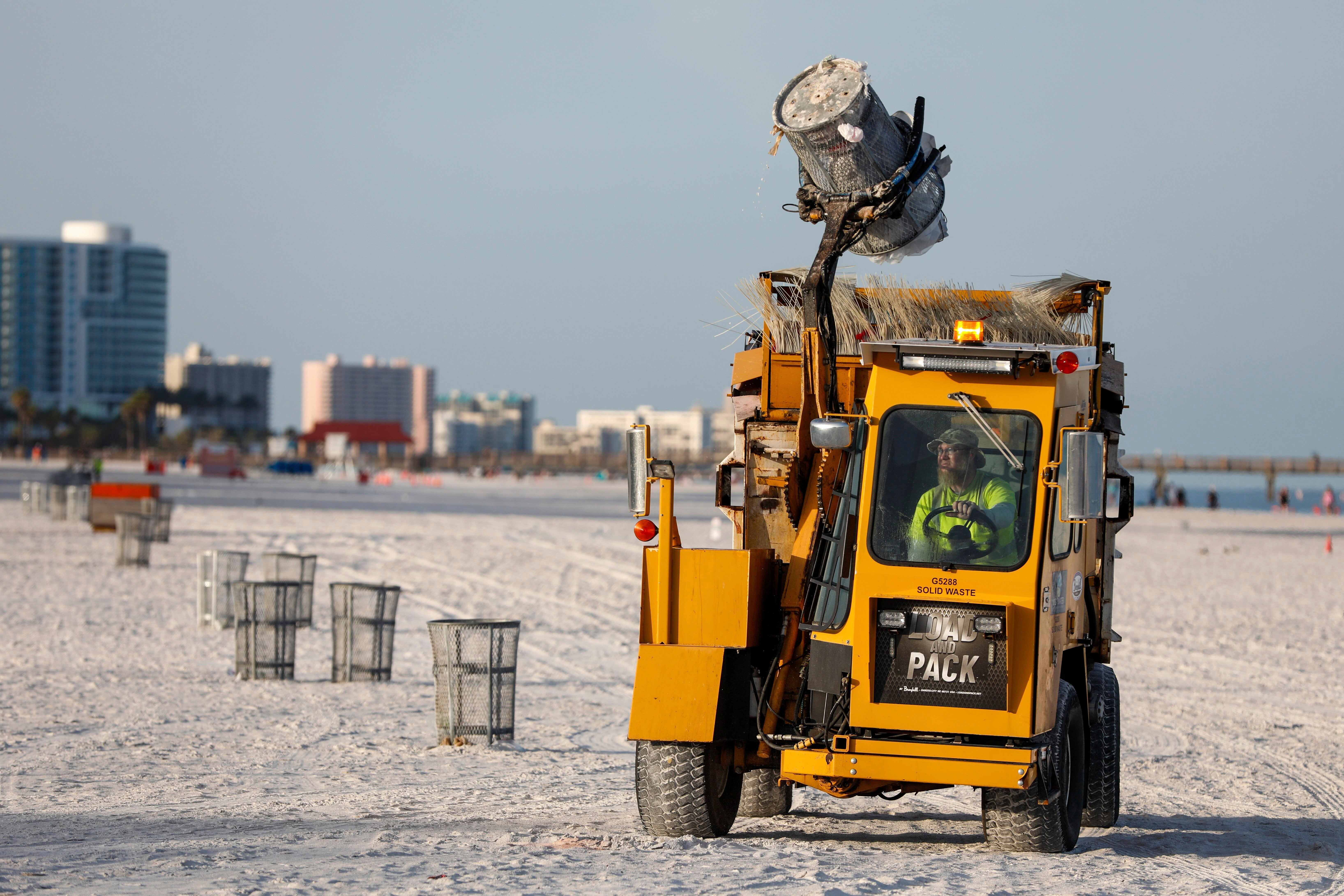 A Clearwater, Florida city worker empties and secures garbage cans along Clearwater Beach as the state prepares for a potential tropical storm to make landfall in the coming days