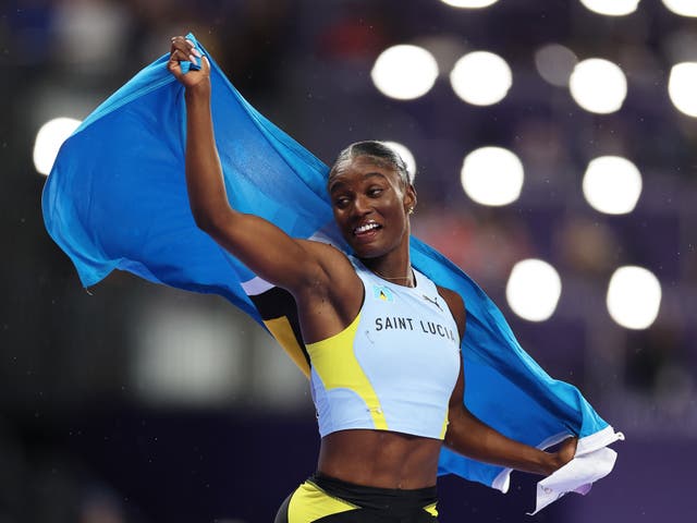 <p>Julien Alfred celebrates with the Saint Lucian flag</p>
