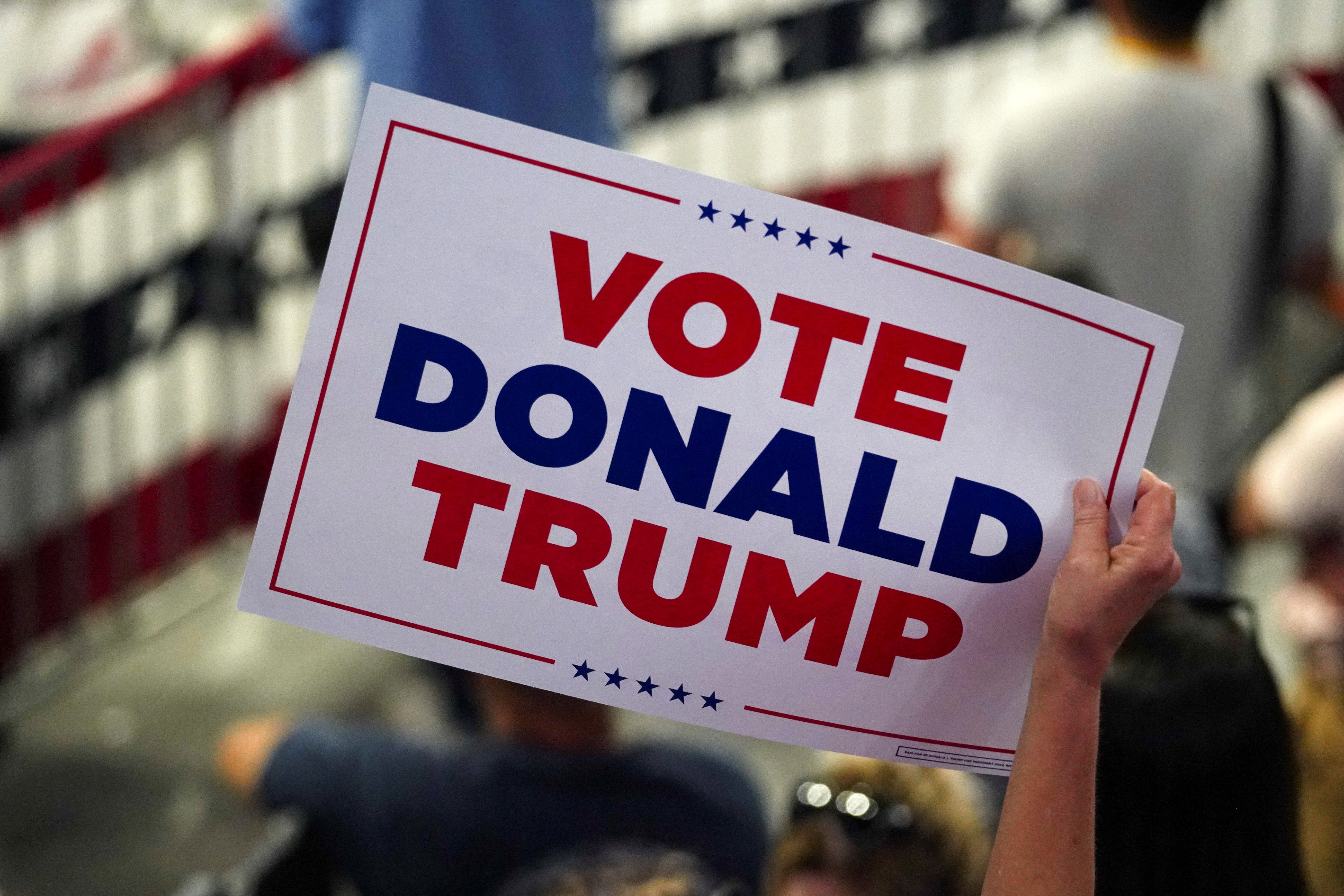 Seorang pendukung memegang plakat pada hari ketika calon presiden dari Partai Republik dan mantan Presiden AS Donald Trump dan pasangannya JD Vance mengadakan rapat umum kampanye di Atlanta, Georgia, AS, 3 Agustus 2024. REUTERS/Megan Varner