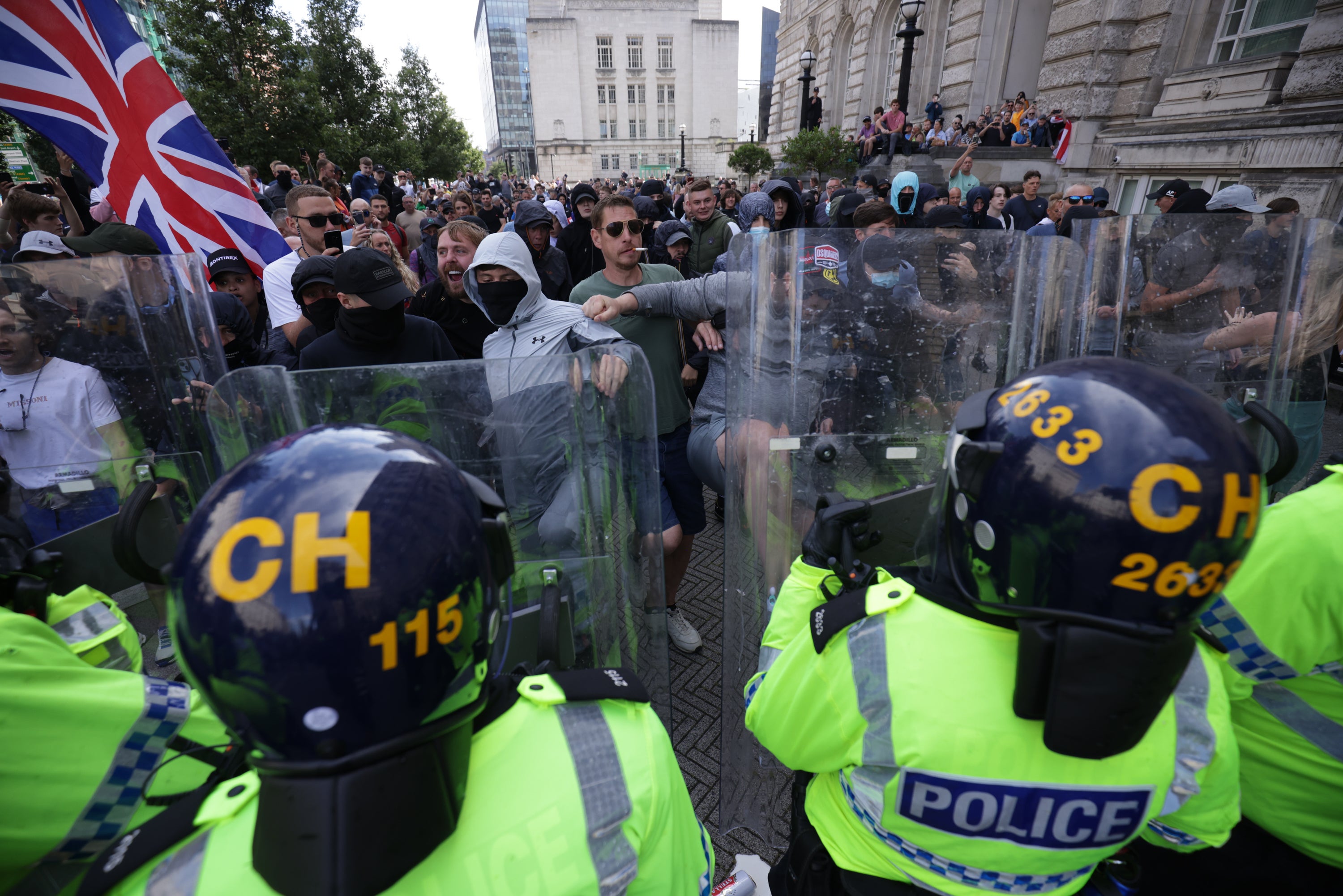 Police officers face rioters in Liverpool