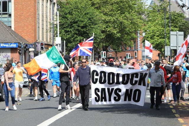 Irish and Union flags were flown side by side at the anti-immigration protest in Belfast on Saturday (Peter Morrison/PA)