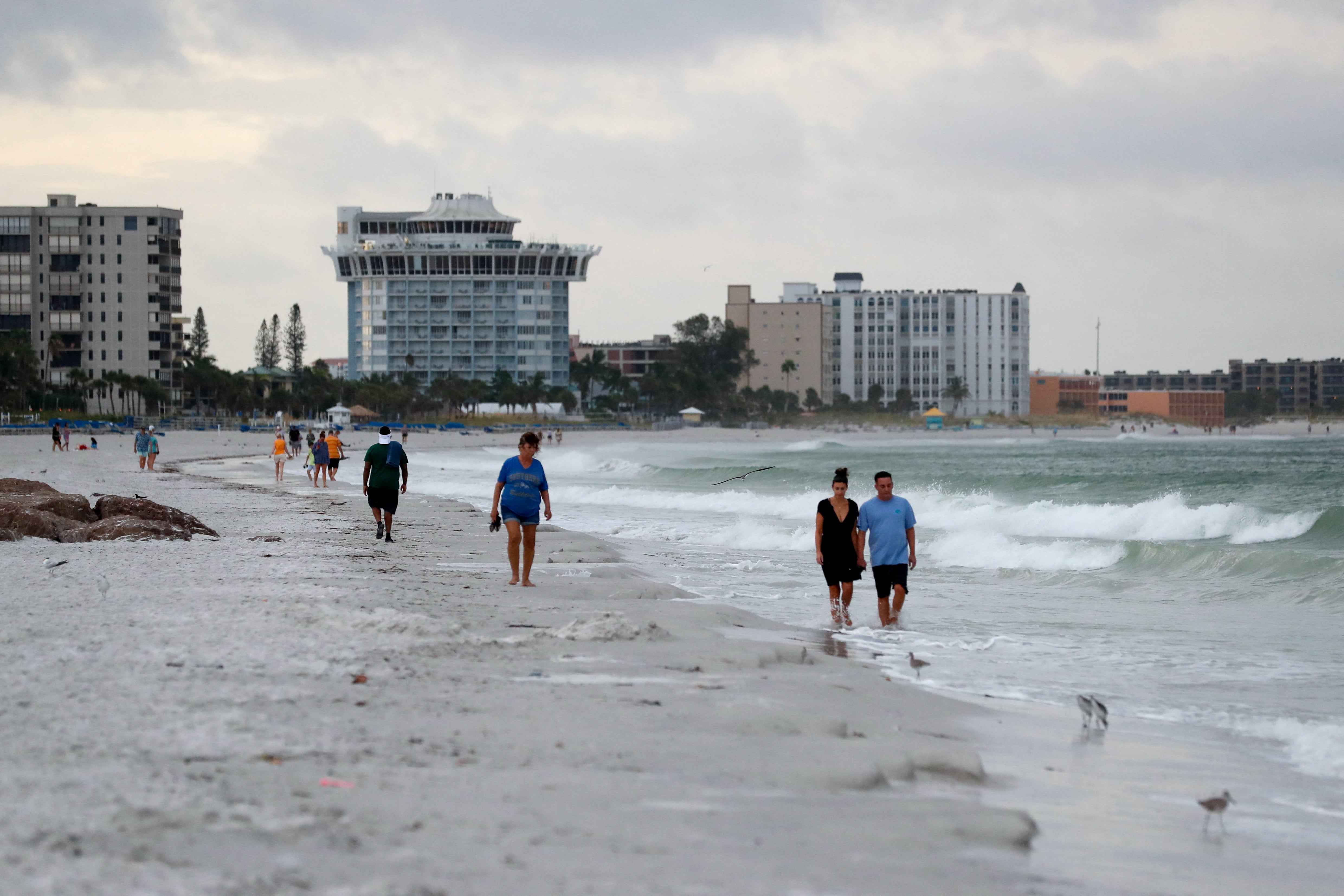 People walk along St. Pete Beach, Florida on Sunday as Tropical Storm Debby approchaes the Gulf Coast