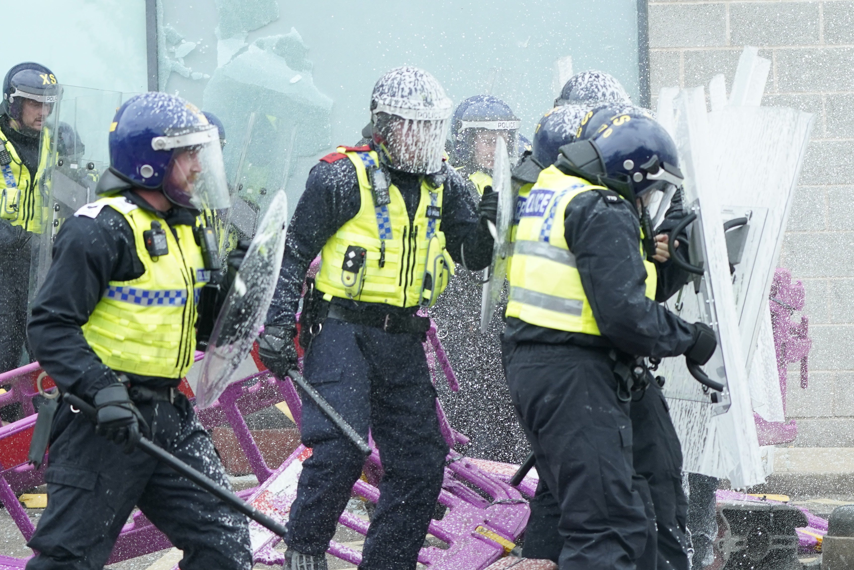 Fire extinguishers are used on police officers as trouble flares during an anti-immigration protest outside the Holiday Inn Express in Rotherham