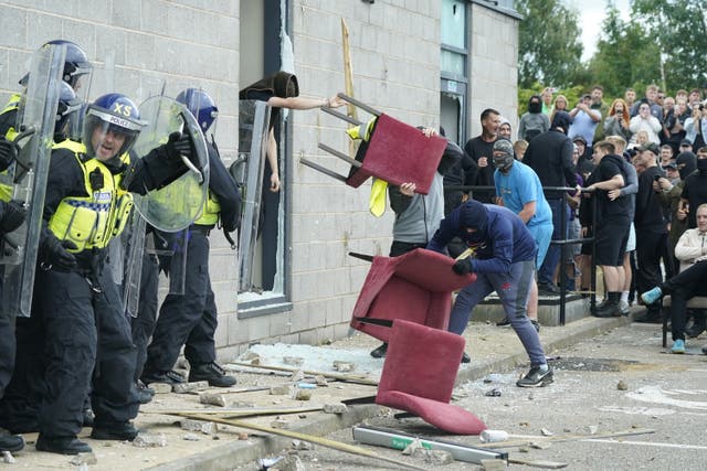 <p>A chair is thrown at police officers outside the Holiday Inn Express in Rotherham (Danny Lawson/PA)</p>