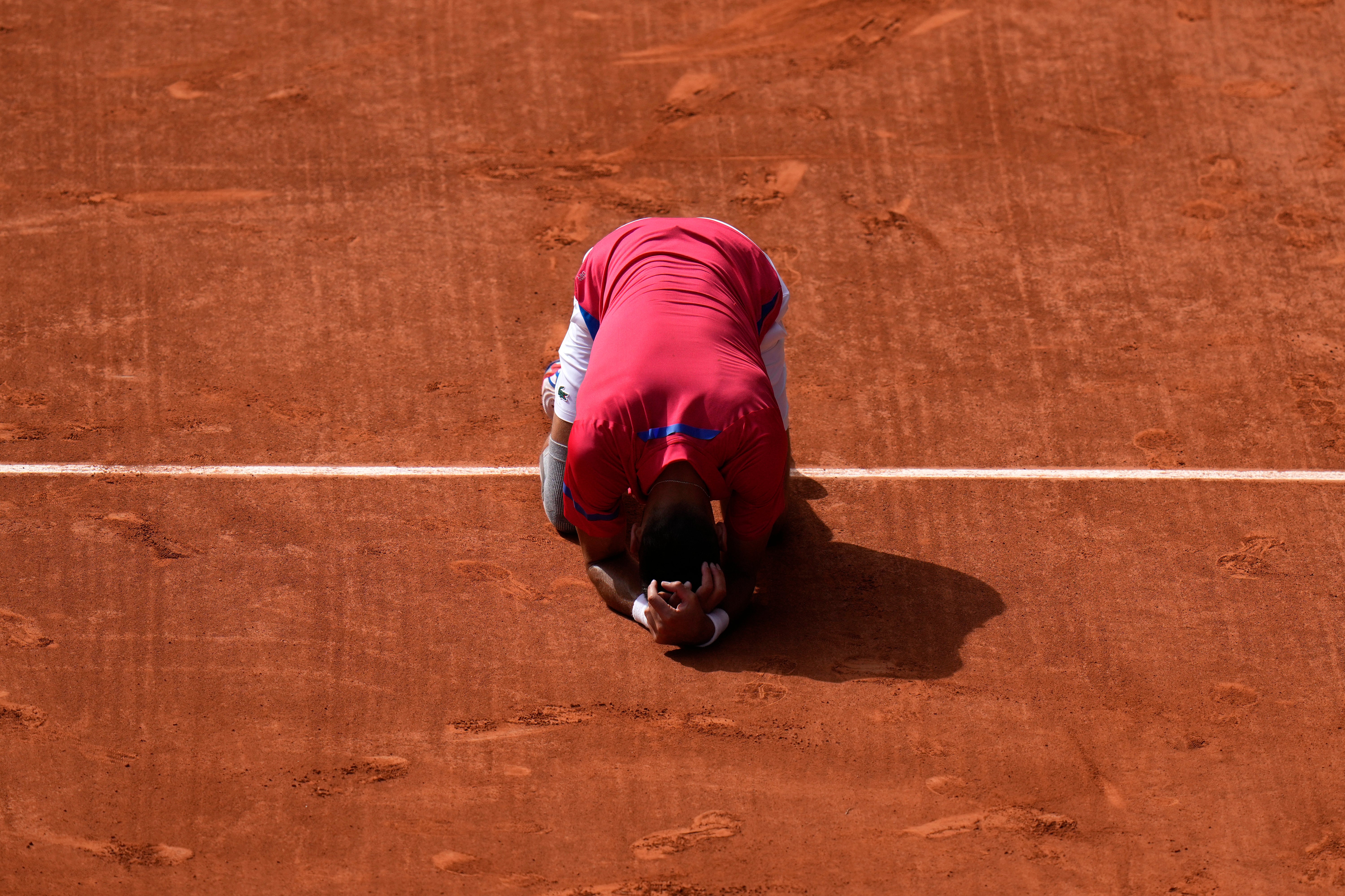 Novak Djokovic drops to his knees on the court (Andy Wong/AP)