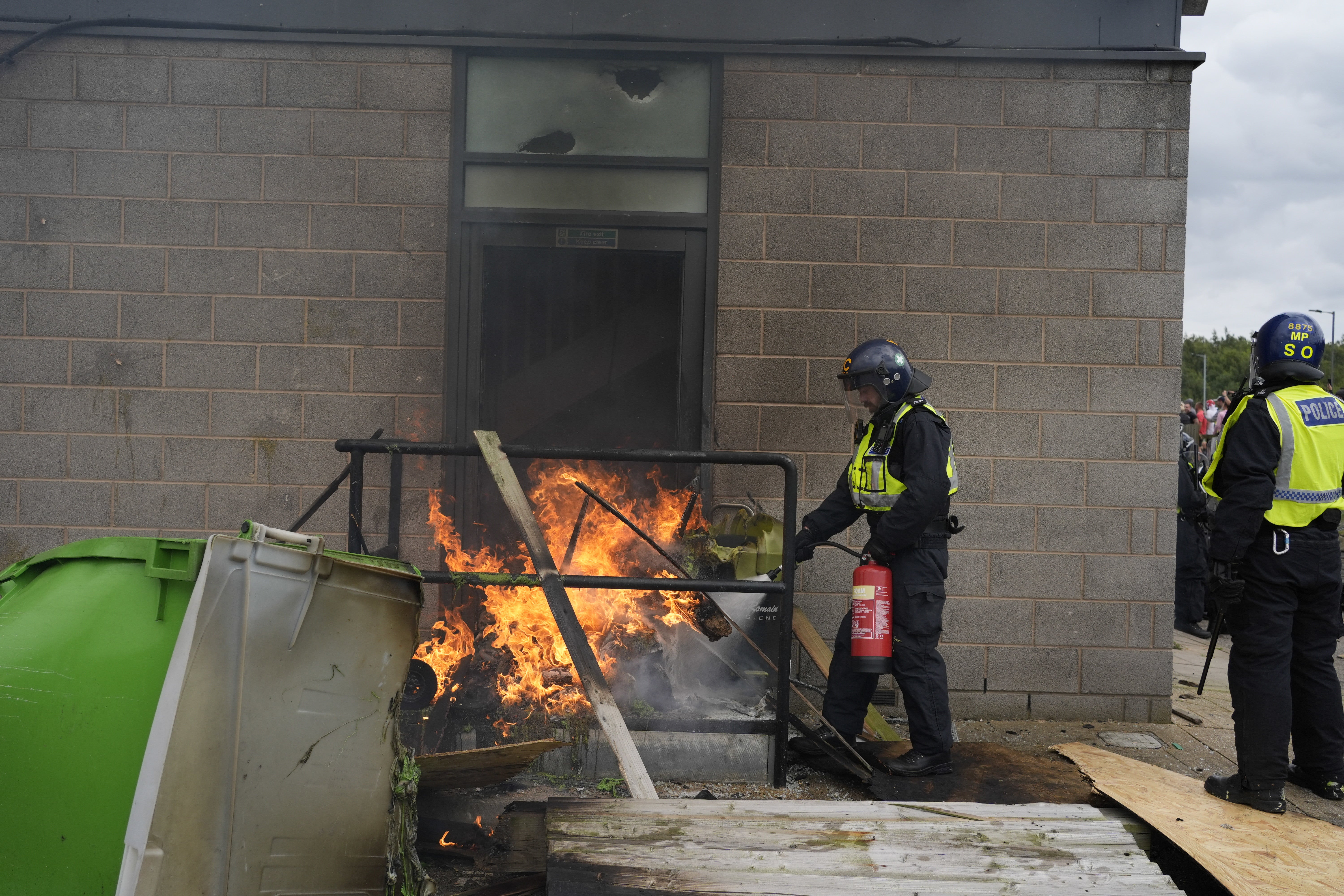 A fire is extinguished by police officers outside the Holiday Inn Express in Rotherham