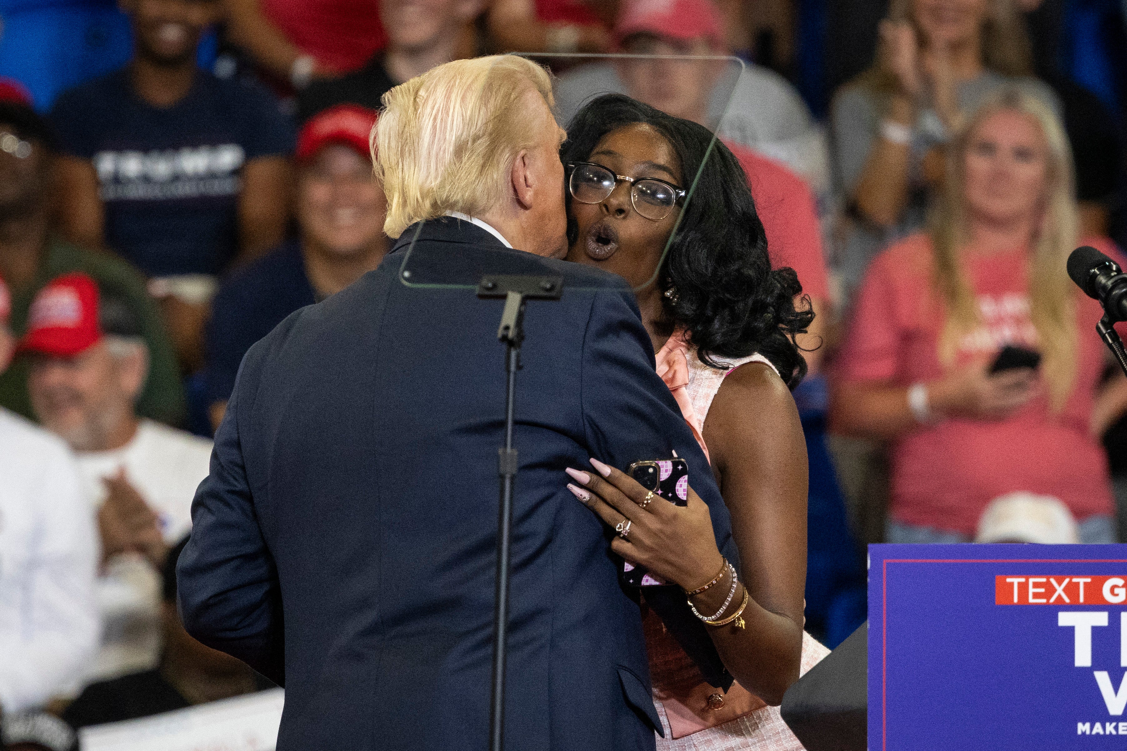 Trump kisses Michaelah Montgomery during Atlanta rally on August 3 and jokes that he once considered ‘never going back’ to Melania after she kissed him at a Chick-fil-A in April