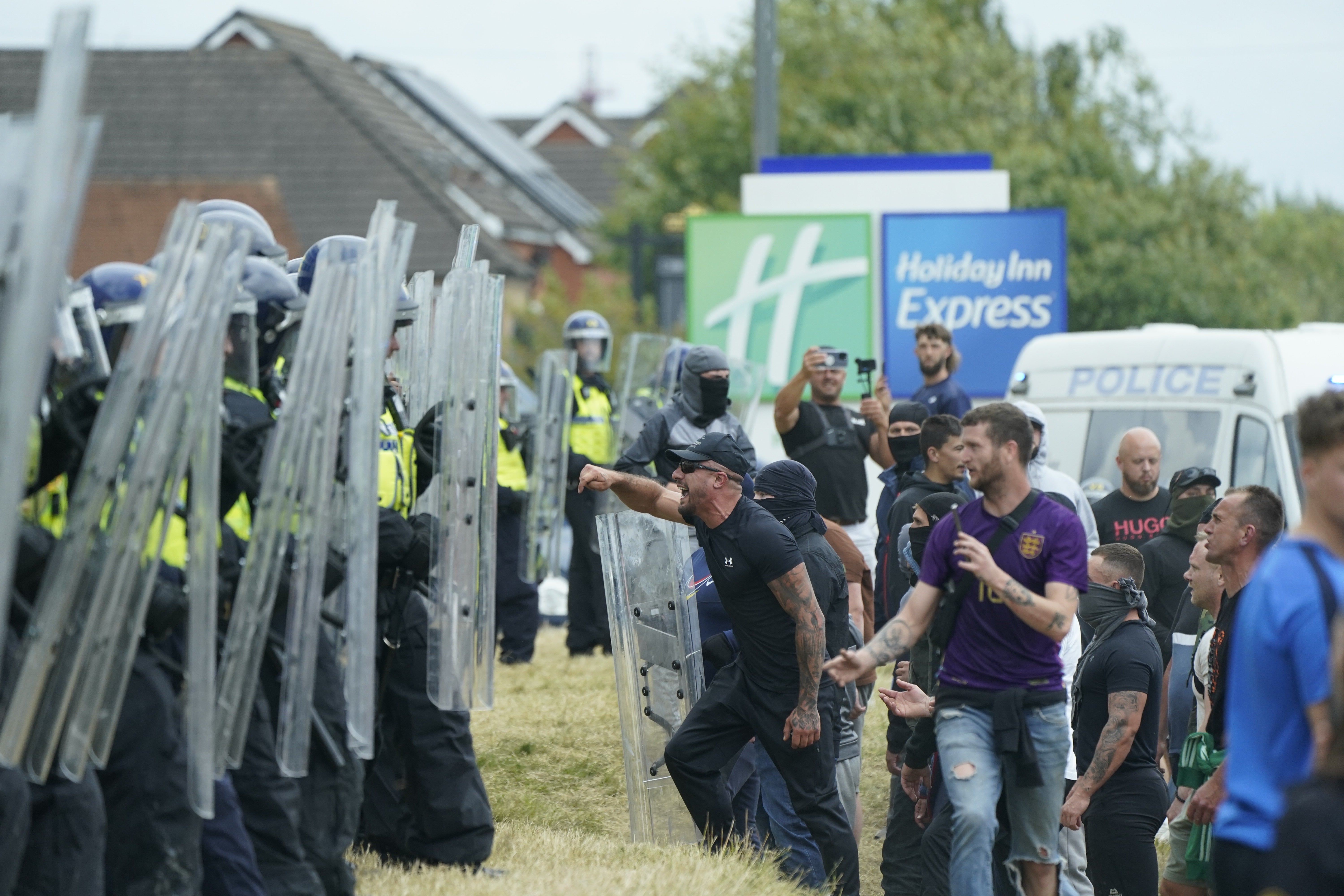 Police officers clash with rioters outside the Holiday Inn Express in Rotherham