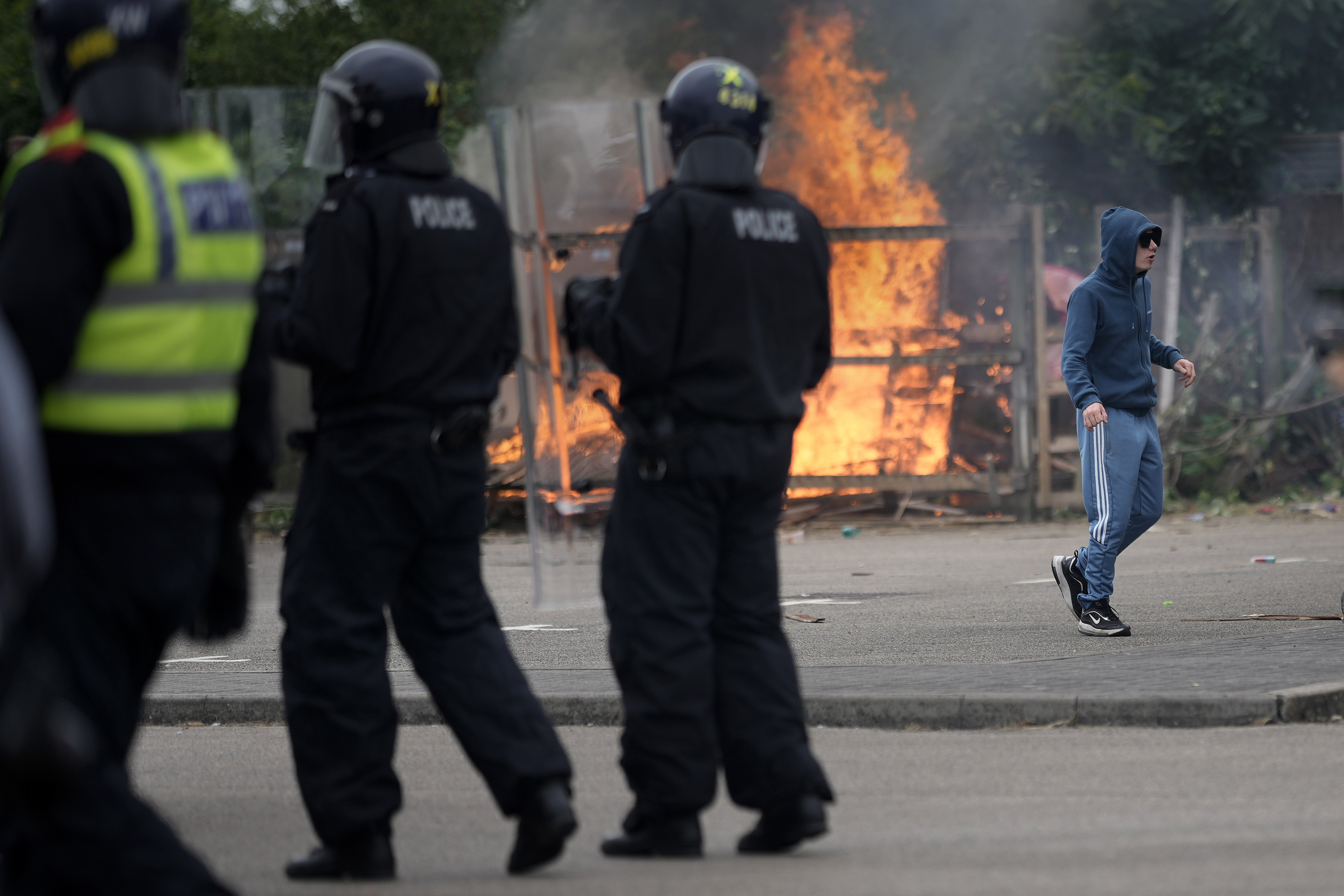 Riot police officers push back anti-migration protesters outside the Holiday Inn Express in Rotherham