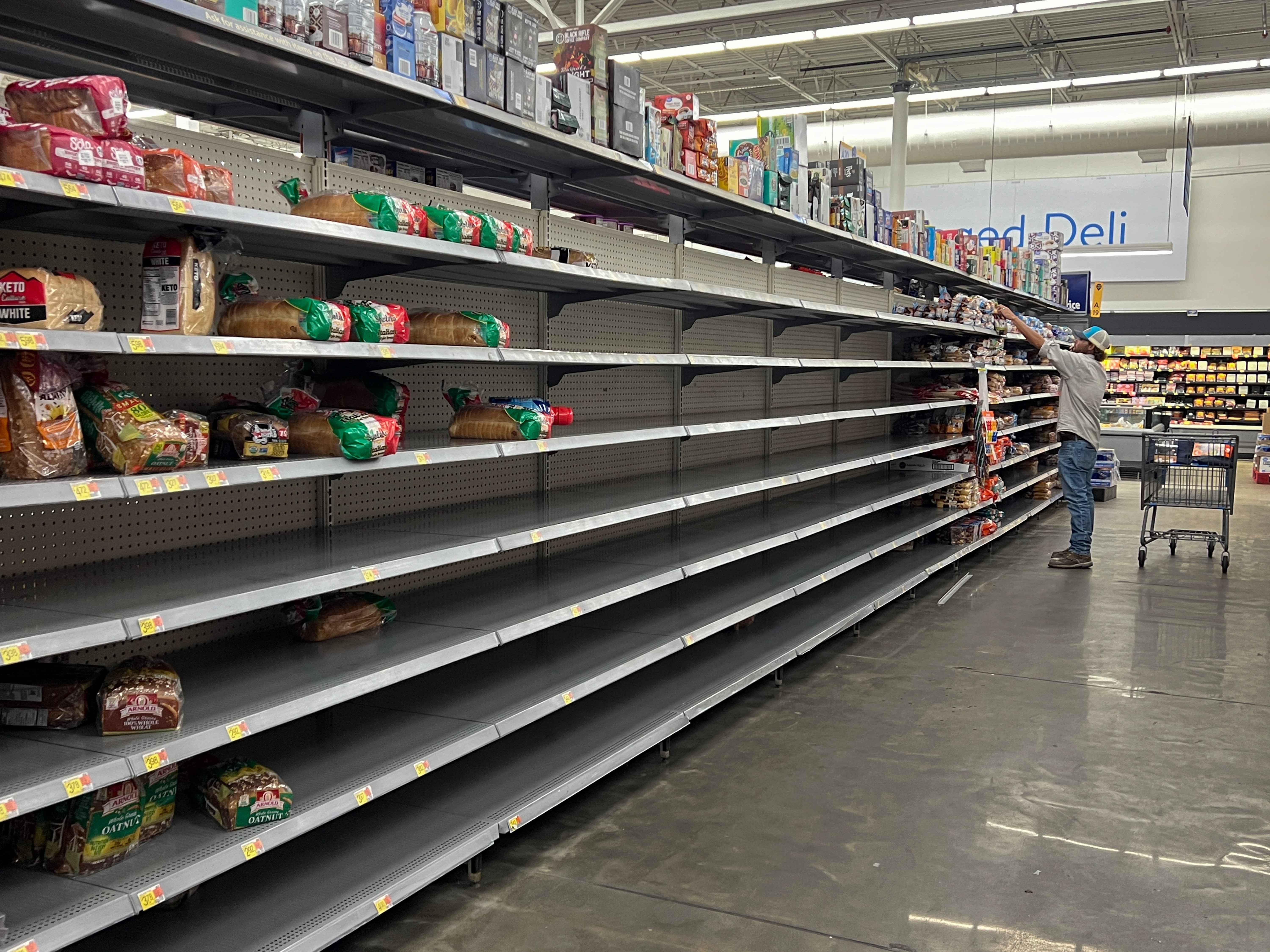 A bread aisle is almost bare in a Walmart store as people stock up before the possible arrival of storm Debby in Cedar Key, Florida