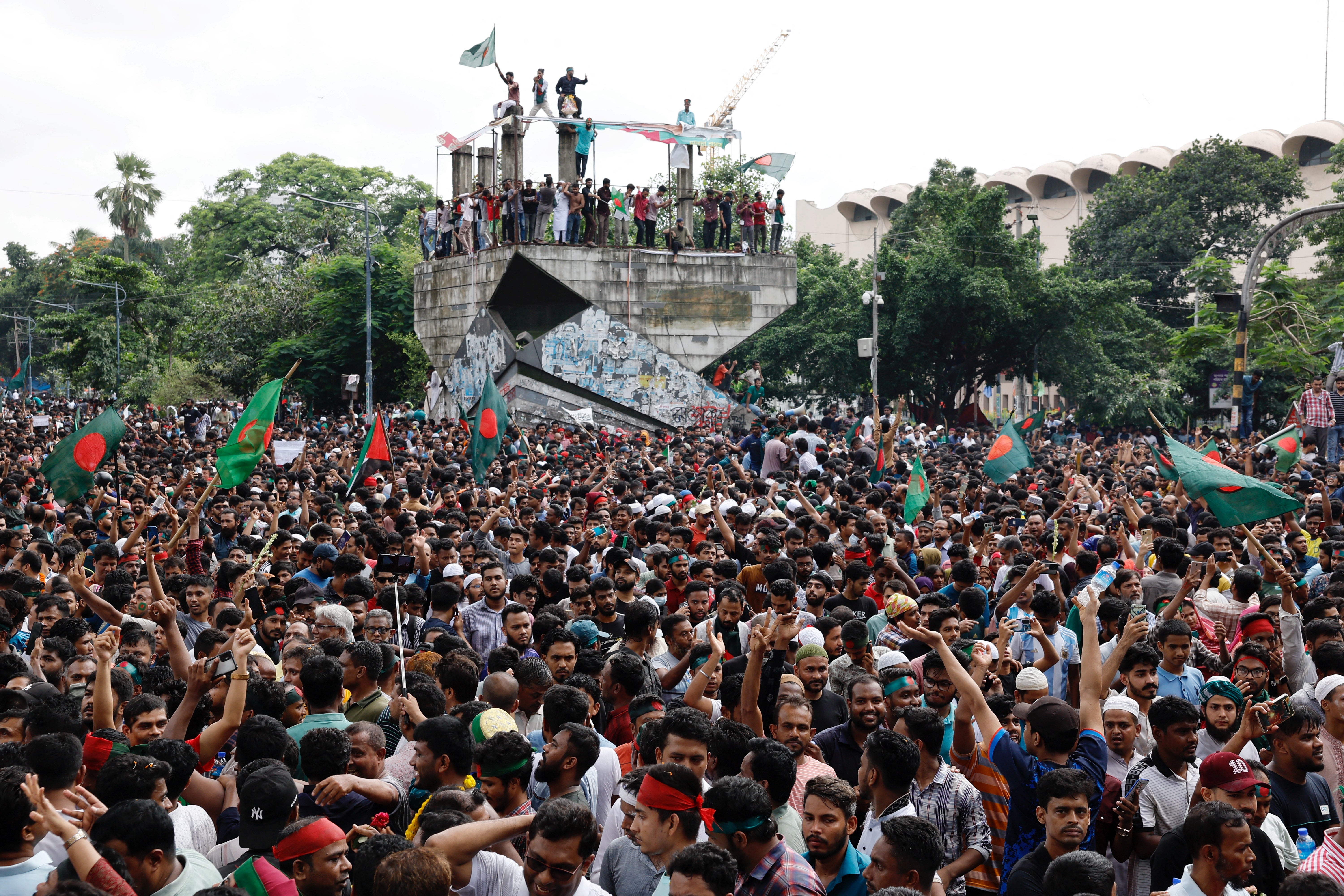 Protesters erupt with joy and unfurl Bangladesh flag after days of demonstrations forces Hasina to leave leave country