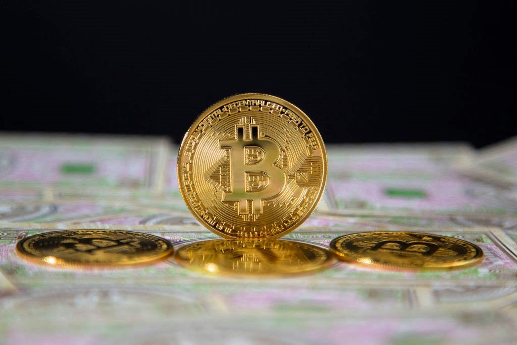 Coins representing bitcoin are placed on banknotes in Briancon, France, 2 May, 2024