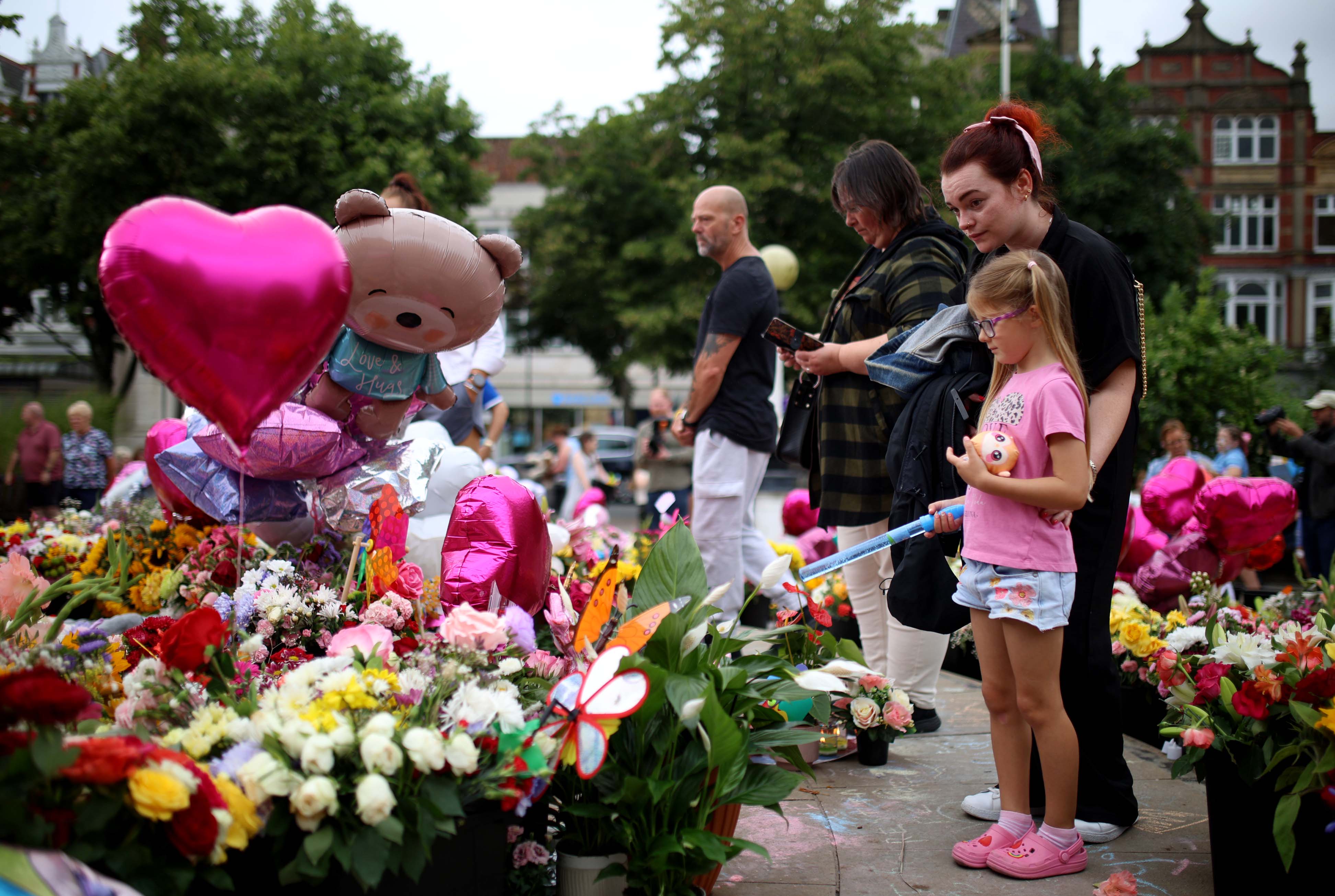 Members of the public at a floral tribute left outside Southport’s Town Hall ahead of a vigil in memory of three children who were killed in a knife attack last Monday