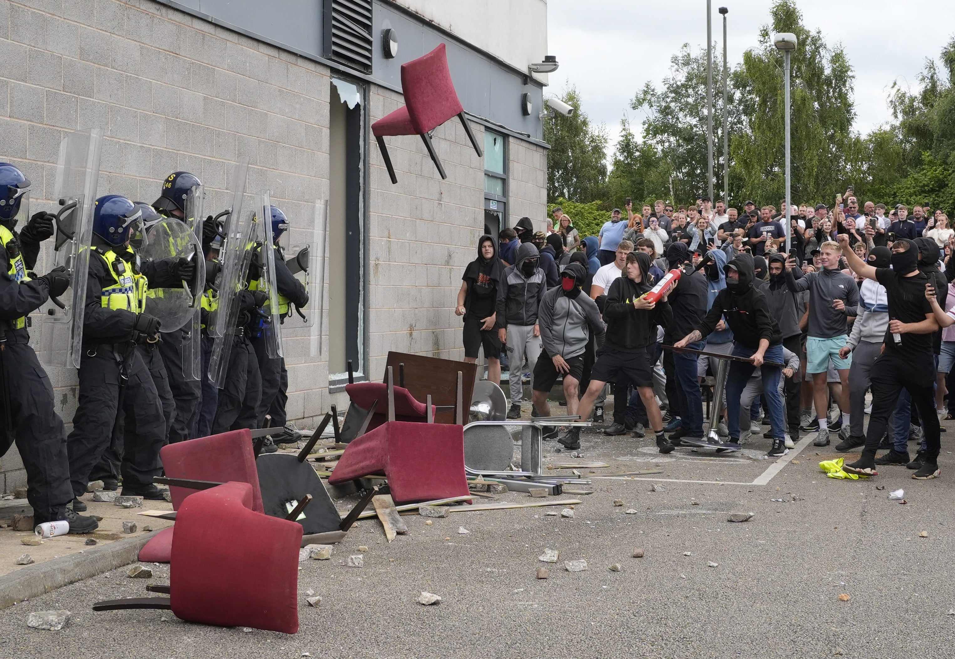 A chair is thrown at police officers during an anti-immigration demonstration outside the Holiday Inn Express in Rotherham, South Yorkshire