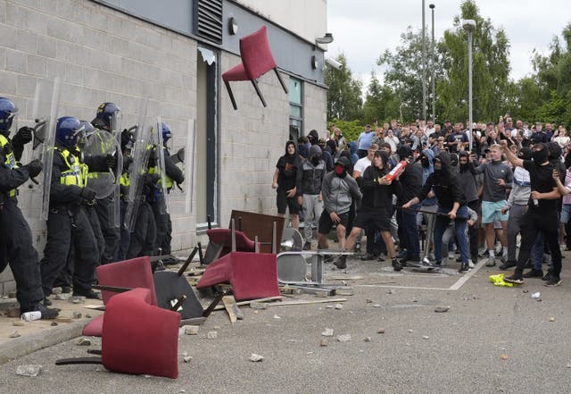 <p>A chair is thrown at police officers as trouble flares during an anti-immigration protest outside the Holiday Inn Express in Rotherham, South Yorkshire. </p>