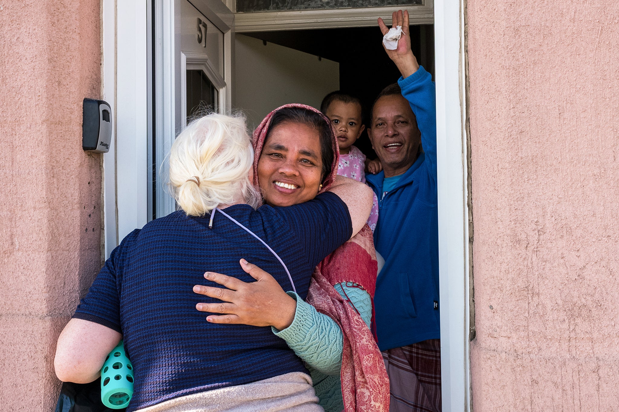 A local volunteer who helped with the clean-up operation hugs Ditu Barua (right), from Bangladesh, after rioters smashed a window of her family home in Middlesbrough