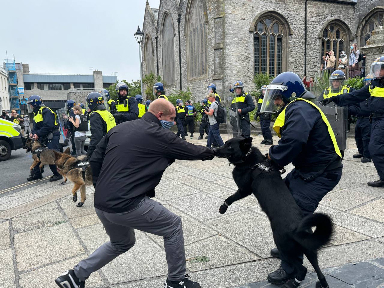 A police dog attacks a protester in Plymouth, Devon, as the town was rocked by far-right and anti-racist demonstrations