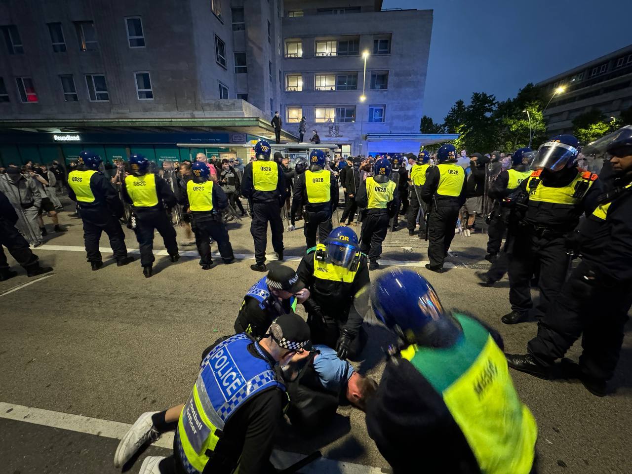 Riot police push a group of far-right protesters back as a man is arrested in Plymouth, Devon