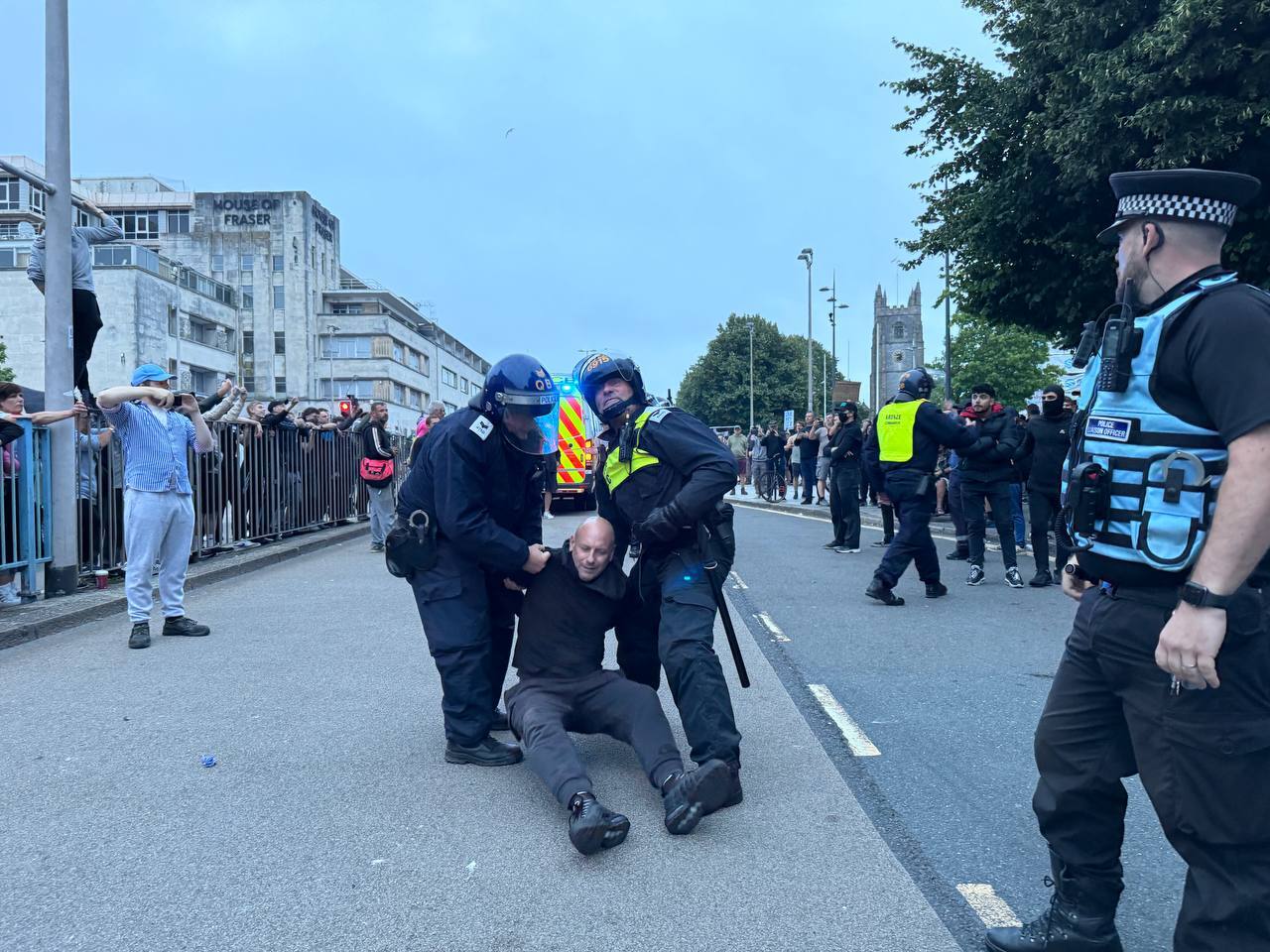 A man is detained by police as a far-right mob descended on Plymouth on Monday evening