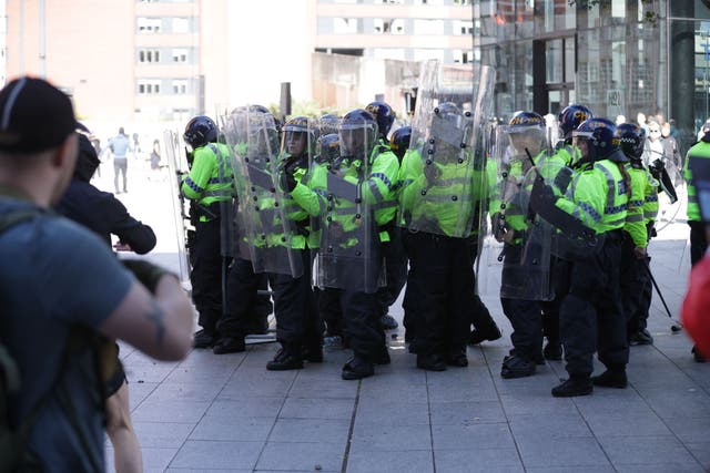 Police shield an injured man (James Speakman/PA)