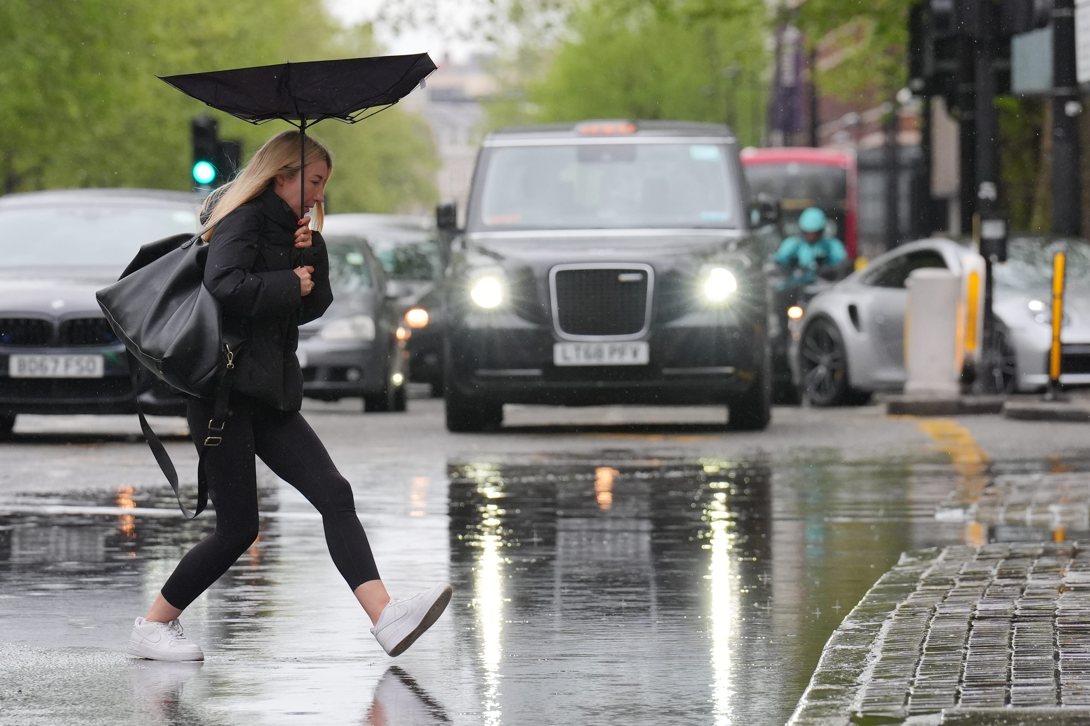 A person walking through the rain in central London (PA)