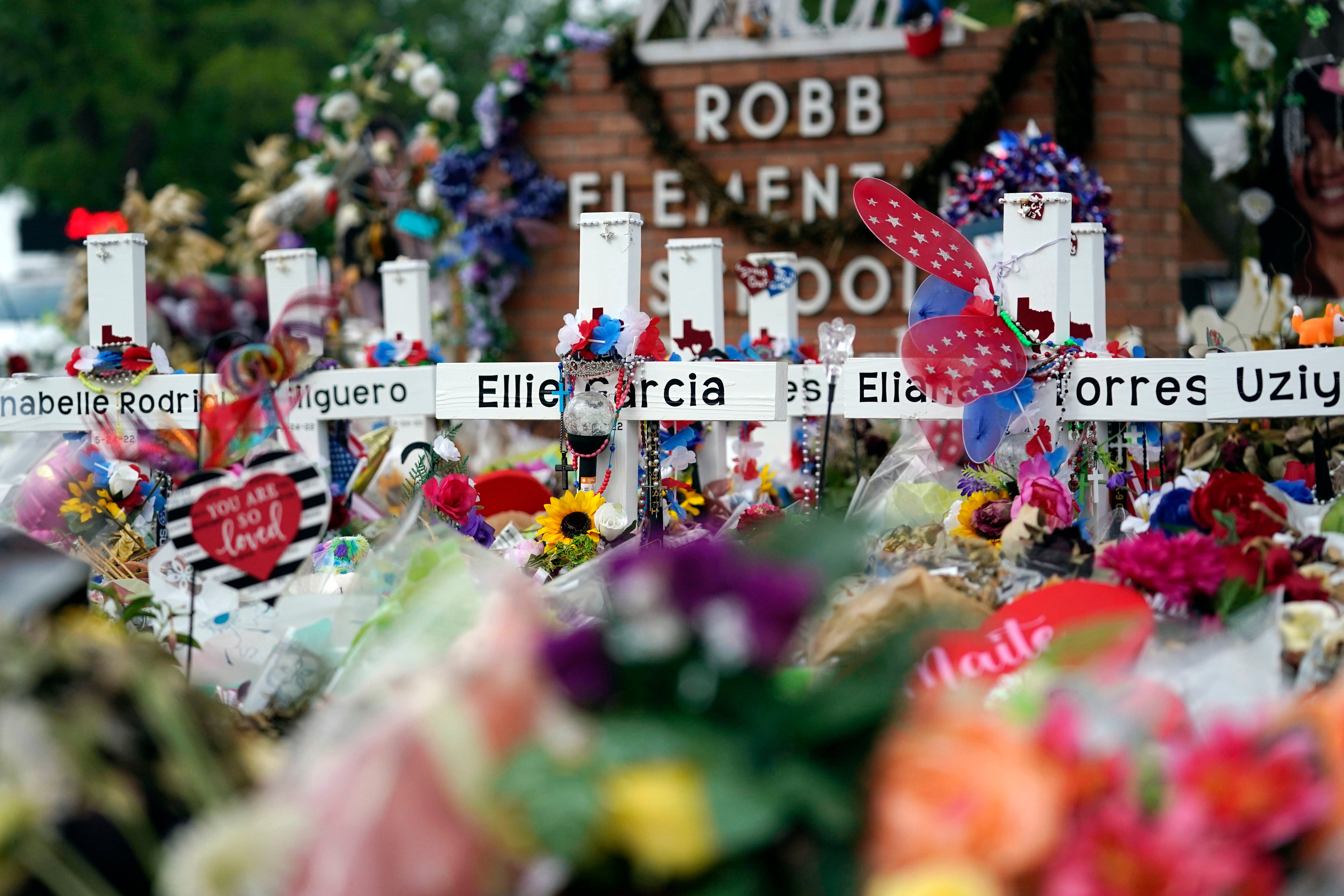 Flowers and other items surround crosses at a memorial on June 9, 2022, for the victims of a shooting at Robb Elementary School in Uvalde, Texas. Newly released information shows panicked 911 calls during the shooting.