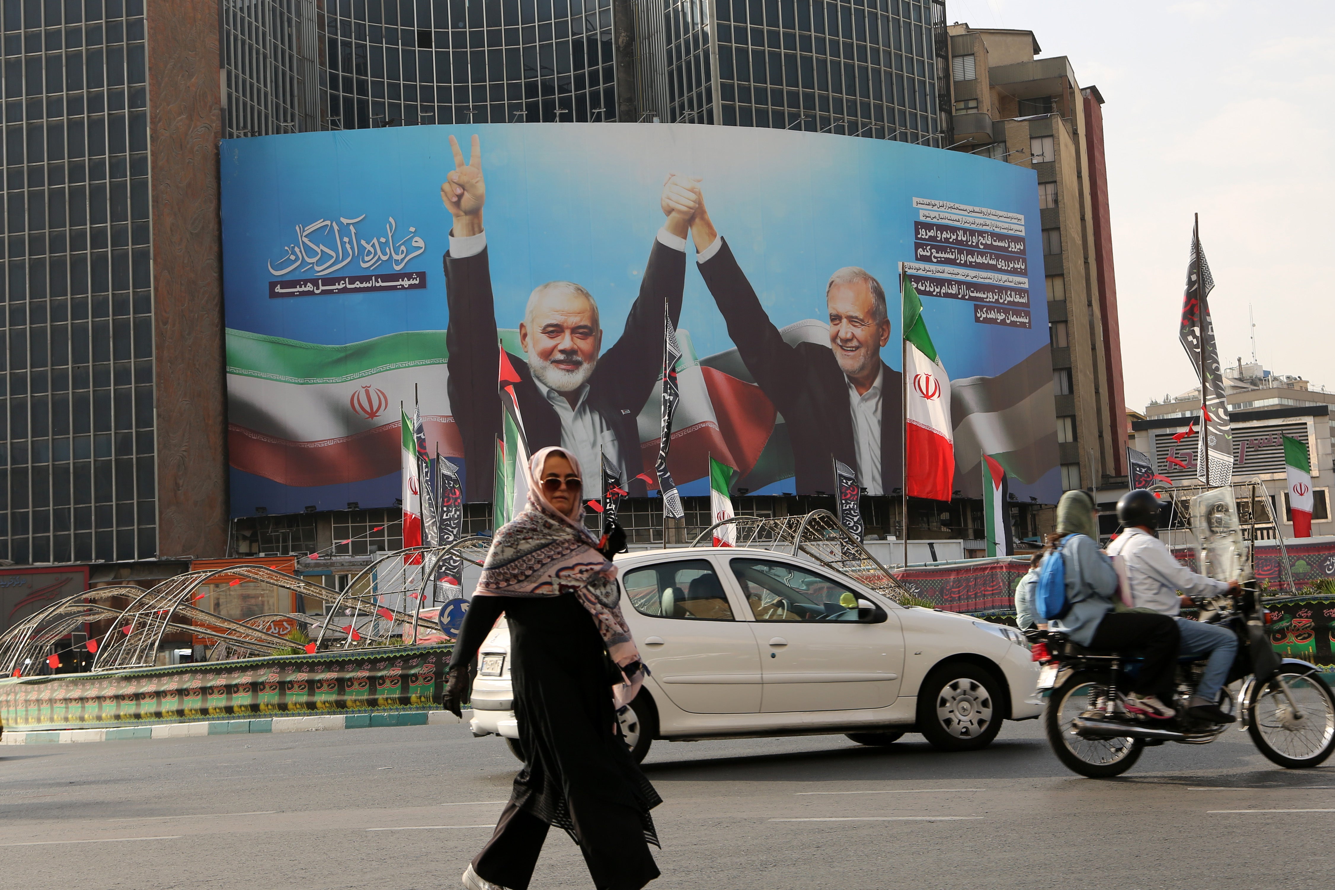 A banner of Iranian president Masoud Pezeshkian's photo taken with Hamas political head Ismail Haniyeh hung at Veliasr Street in Tehran