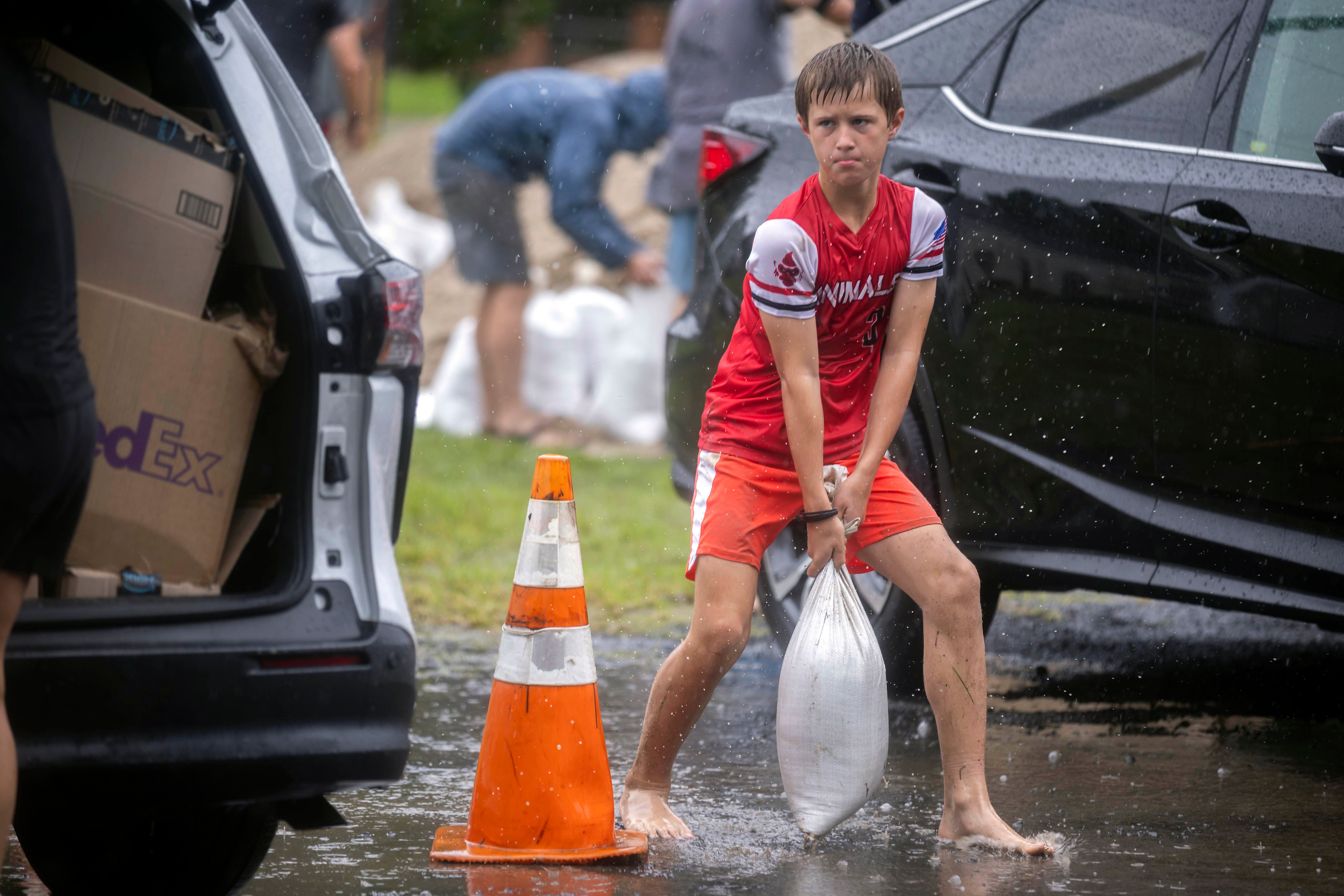 Brantley Schnabel helps his family carry sandbags to their van in Savannah, Georgia