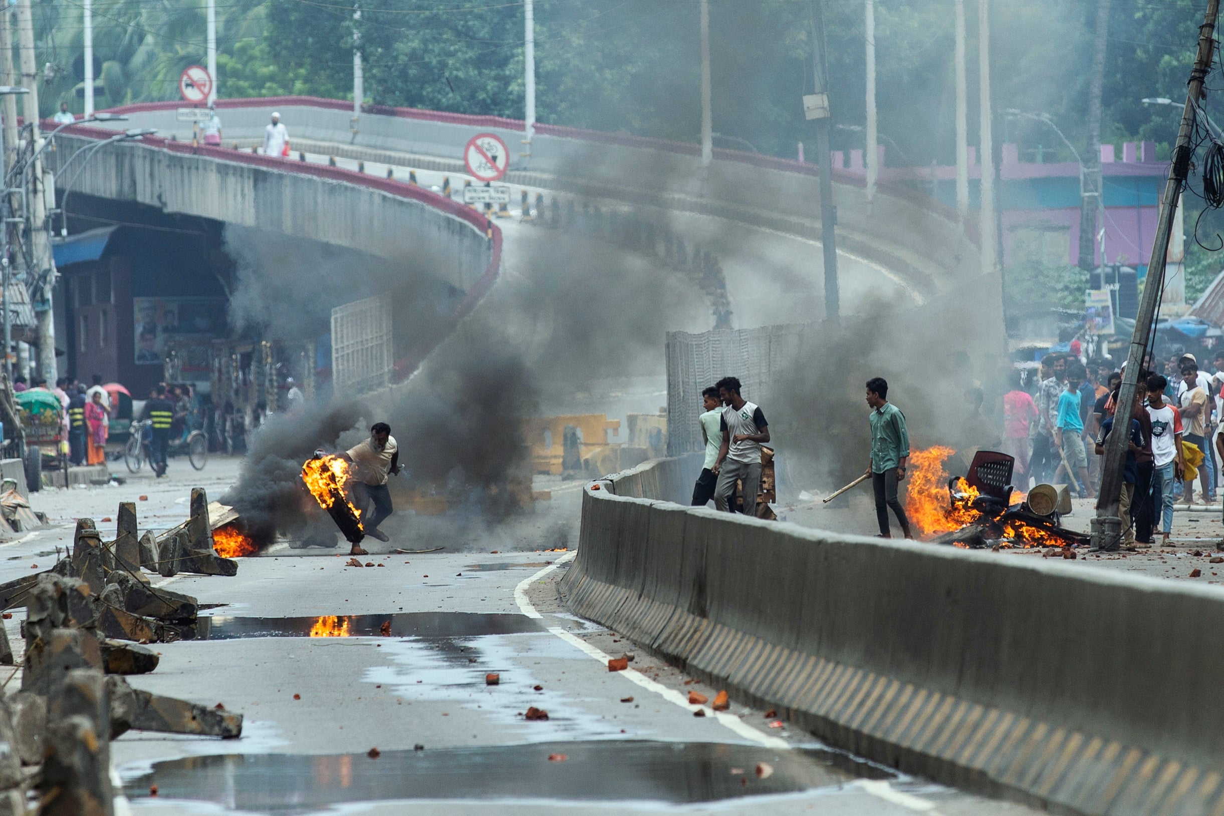 A protester throws a burning rubber tire during a protest