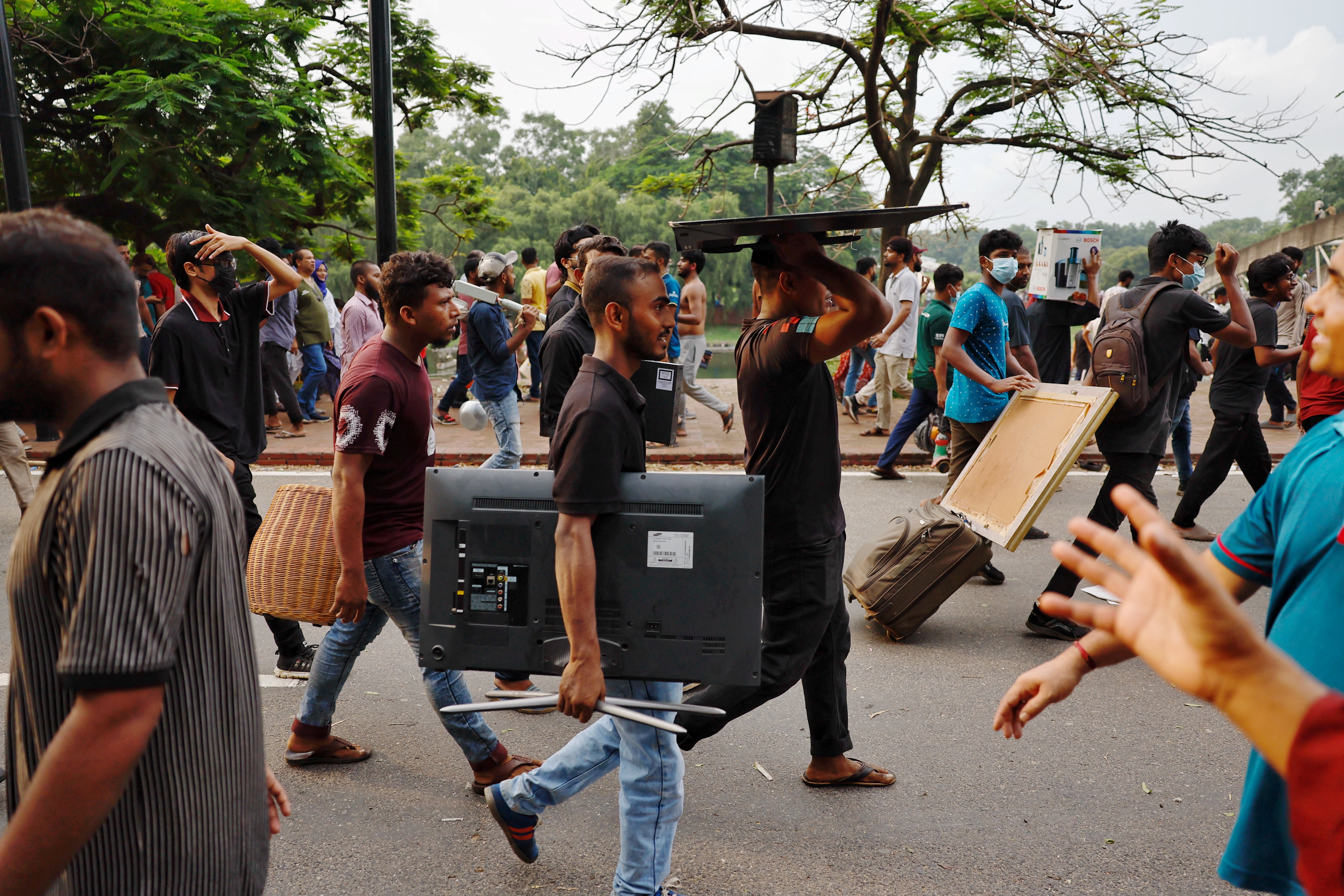 People carry looted items from the Ganabhaban after the resignation of PM Sheikh Hasina in Dhaka