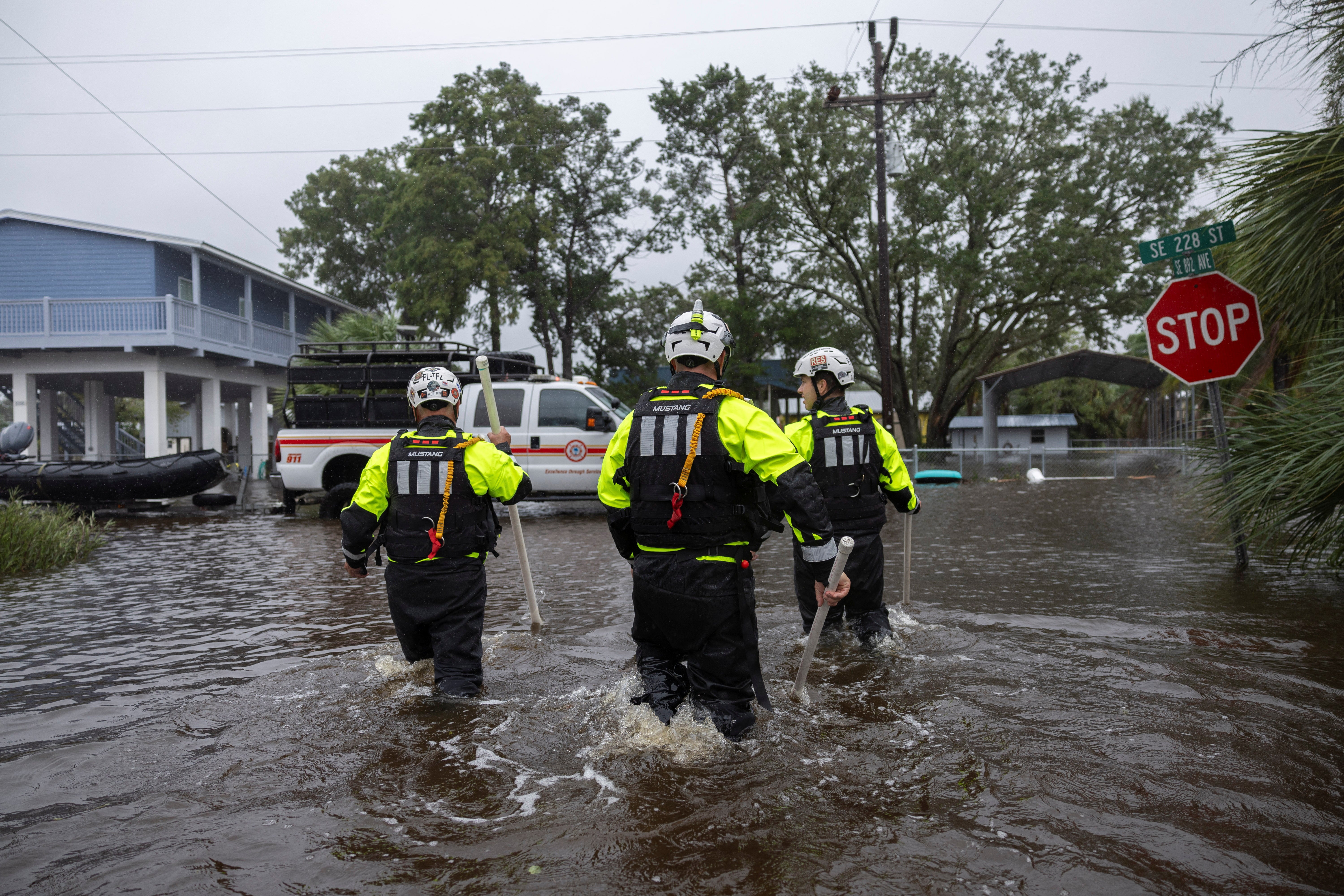 Miami Search and Rescue Fire Department personnel search for people in flooded houses after Hurricane Debby