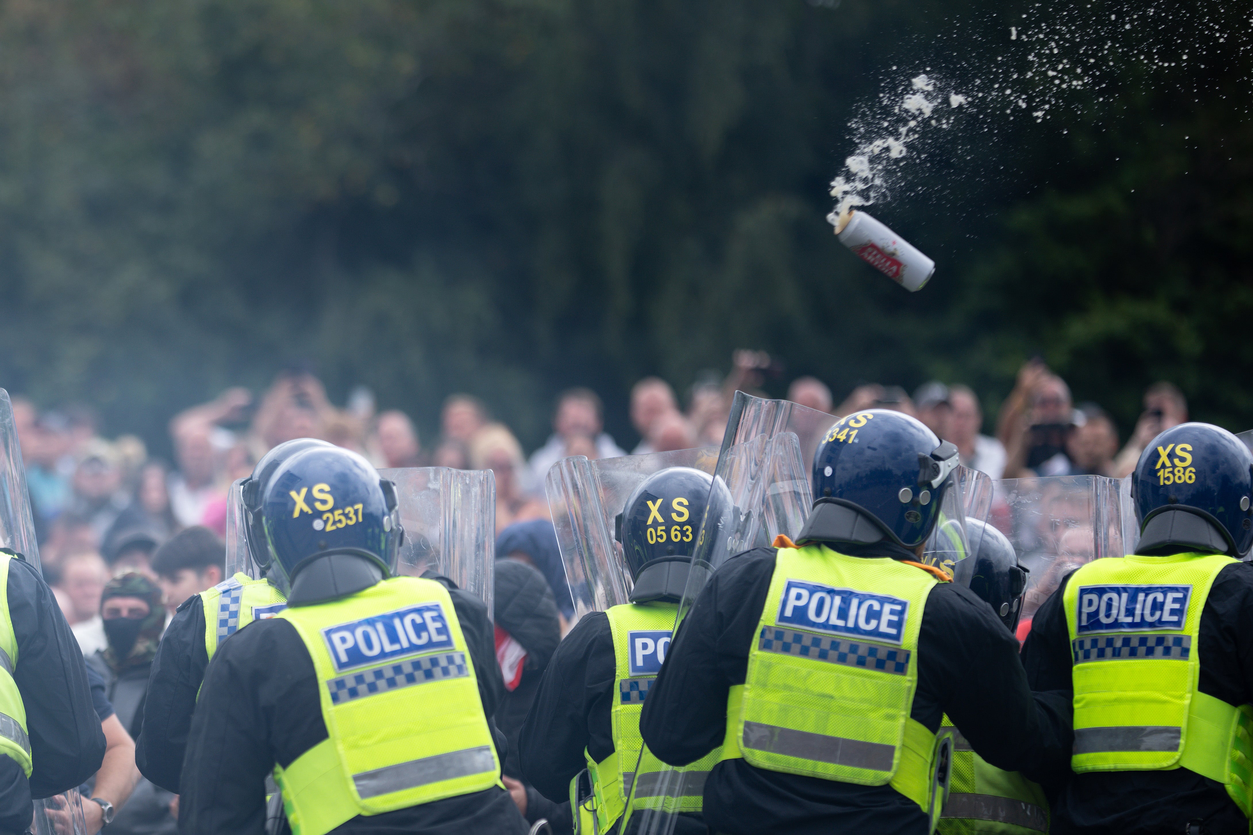 Police officers with shields push back rioters who threw cans at them in Rotherham