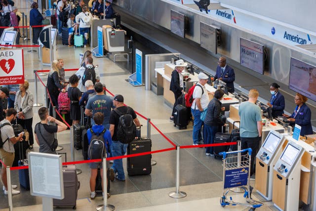 <p>Passengers wait in line at American Airlines in Terminal B at the Philadelphia International Airport</p>