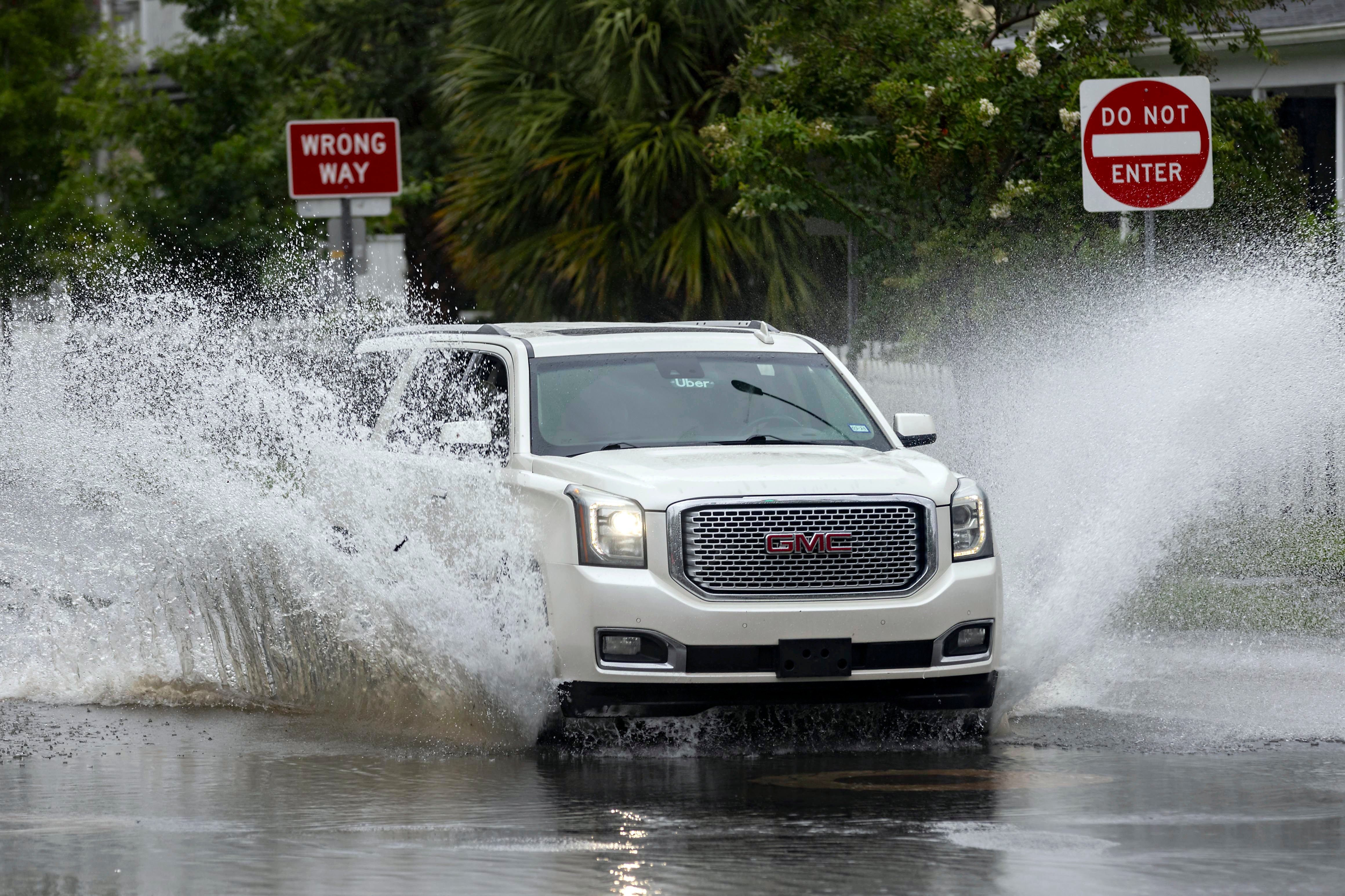 A vehicle drives through a flooded street in Savannah, Georgia amid Tropical Storm Debby