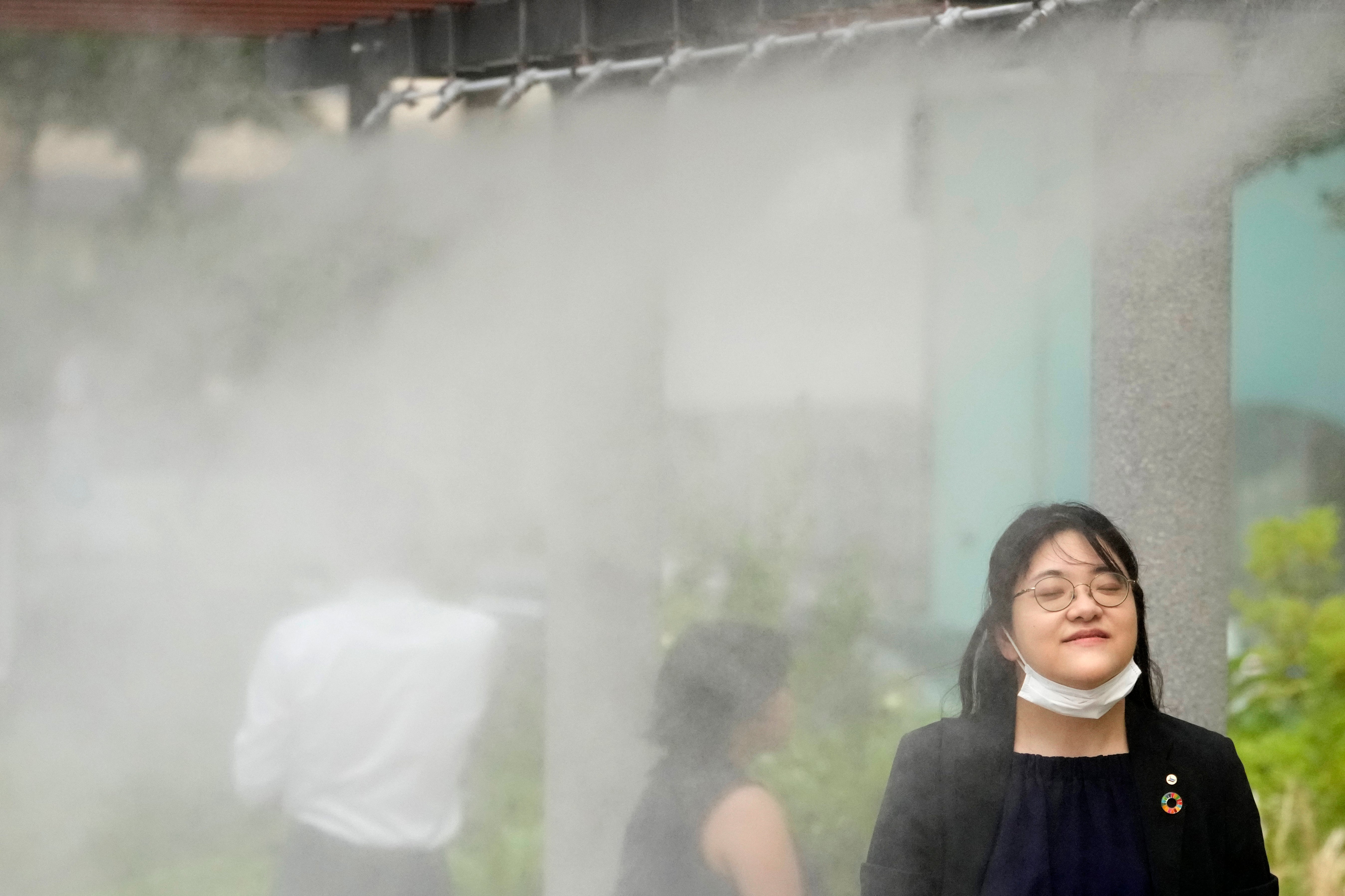 People cool off at a cooling mist spot on July 4, 2024, in Tokyo