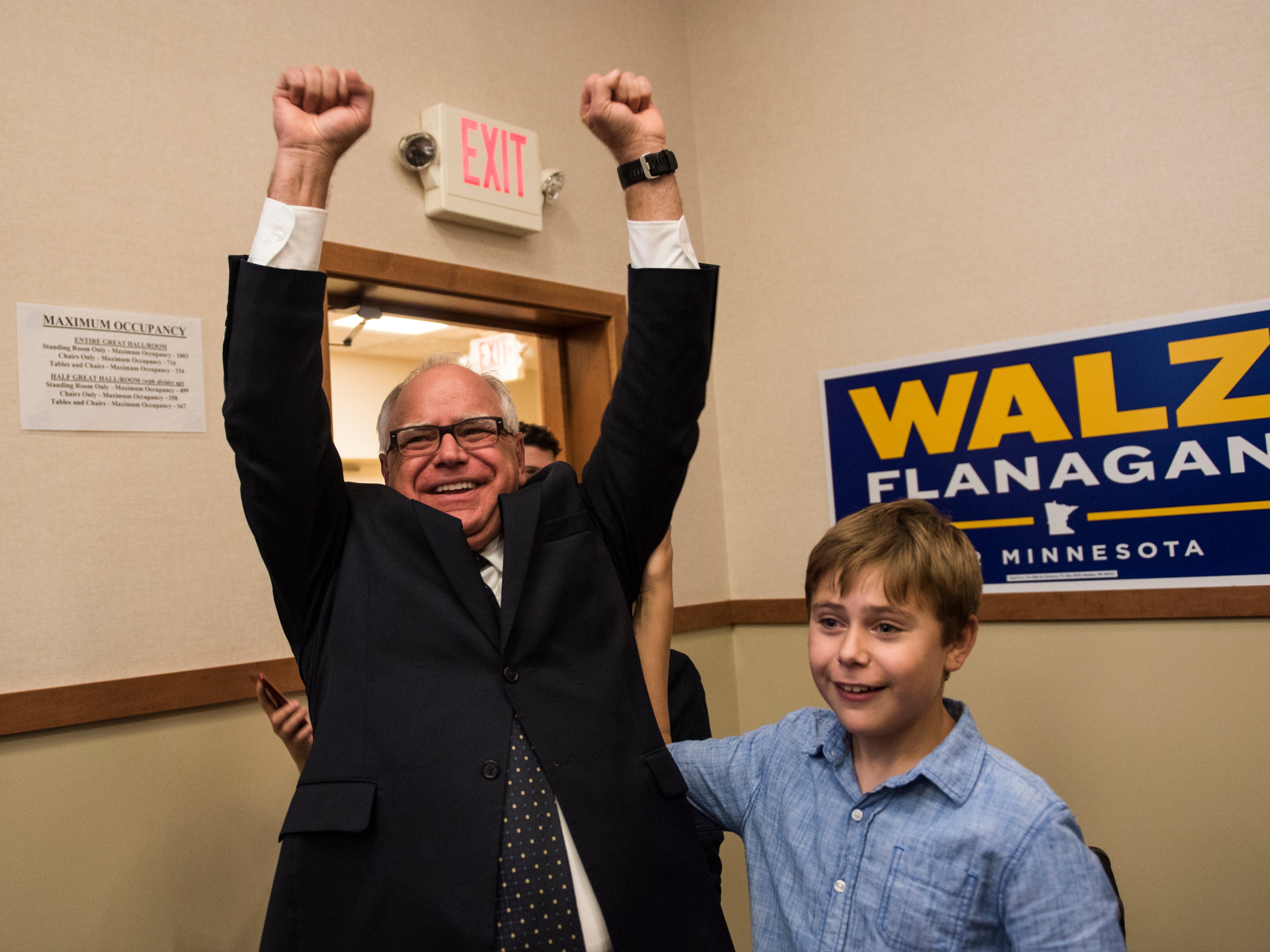 Tim Walz and his son Gus Walz celebrate while entering his election night party on August 14, 2018 in St Paul, Minnesota. He was re-elected as governor in 2022