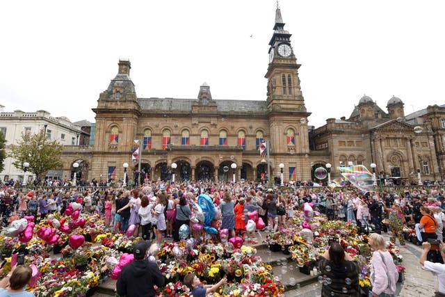 <p>Members of the public form bubbles outside the Town Hall during a vigil to remember the victims of the stabbing attack last Monday in Southport</p>