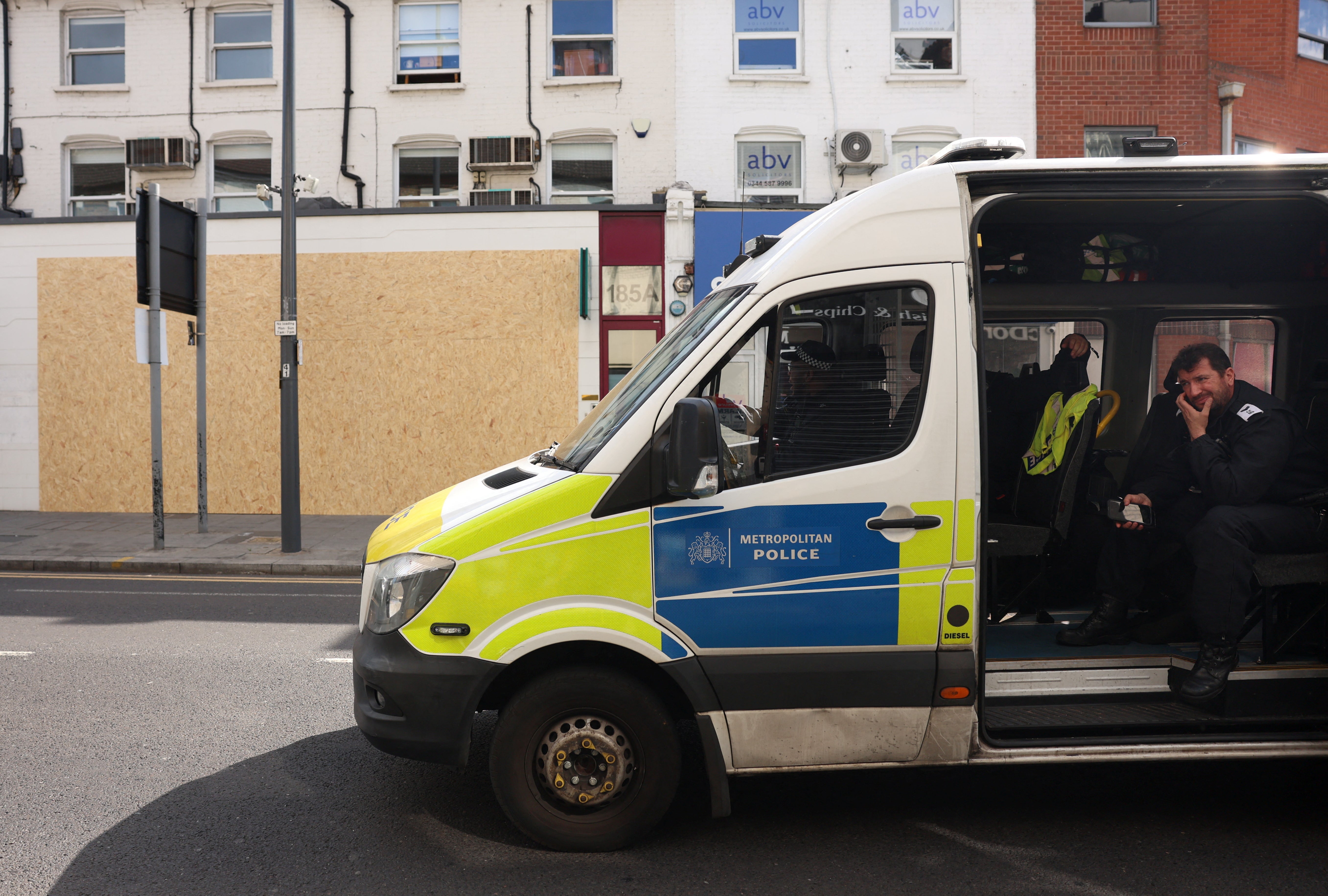 A police van is seen parked near Waltham Forest Immigration Bureau, which has been boarded up as a protective measure against damage from riots, August 7, 2024