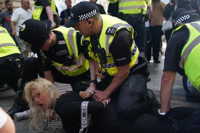 <p>A woman is restrained during disorder in Nottingham </p>