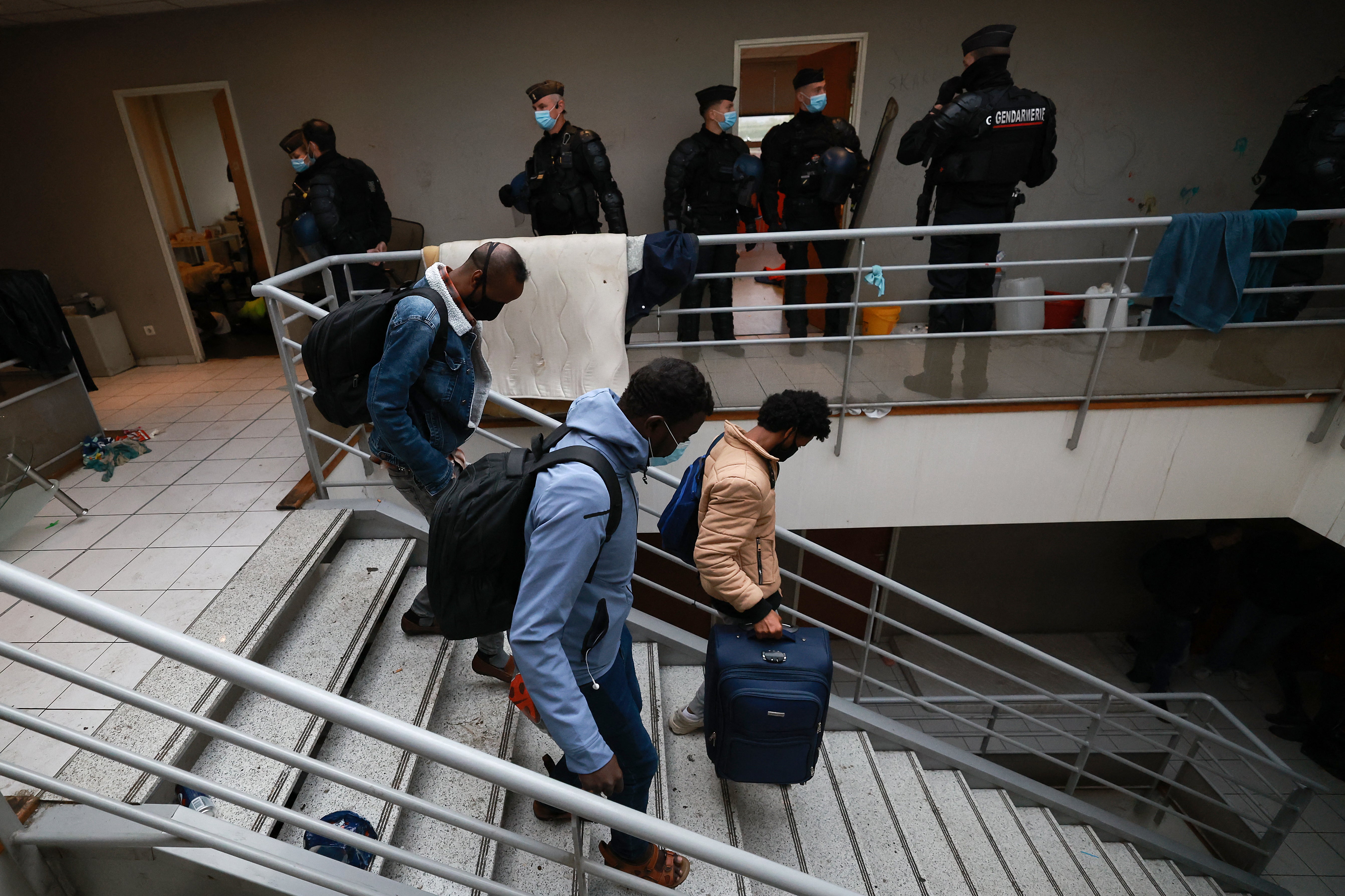 French gendarmes stand guard as migrants are evicted from a squat in Vitry-sur-Seine