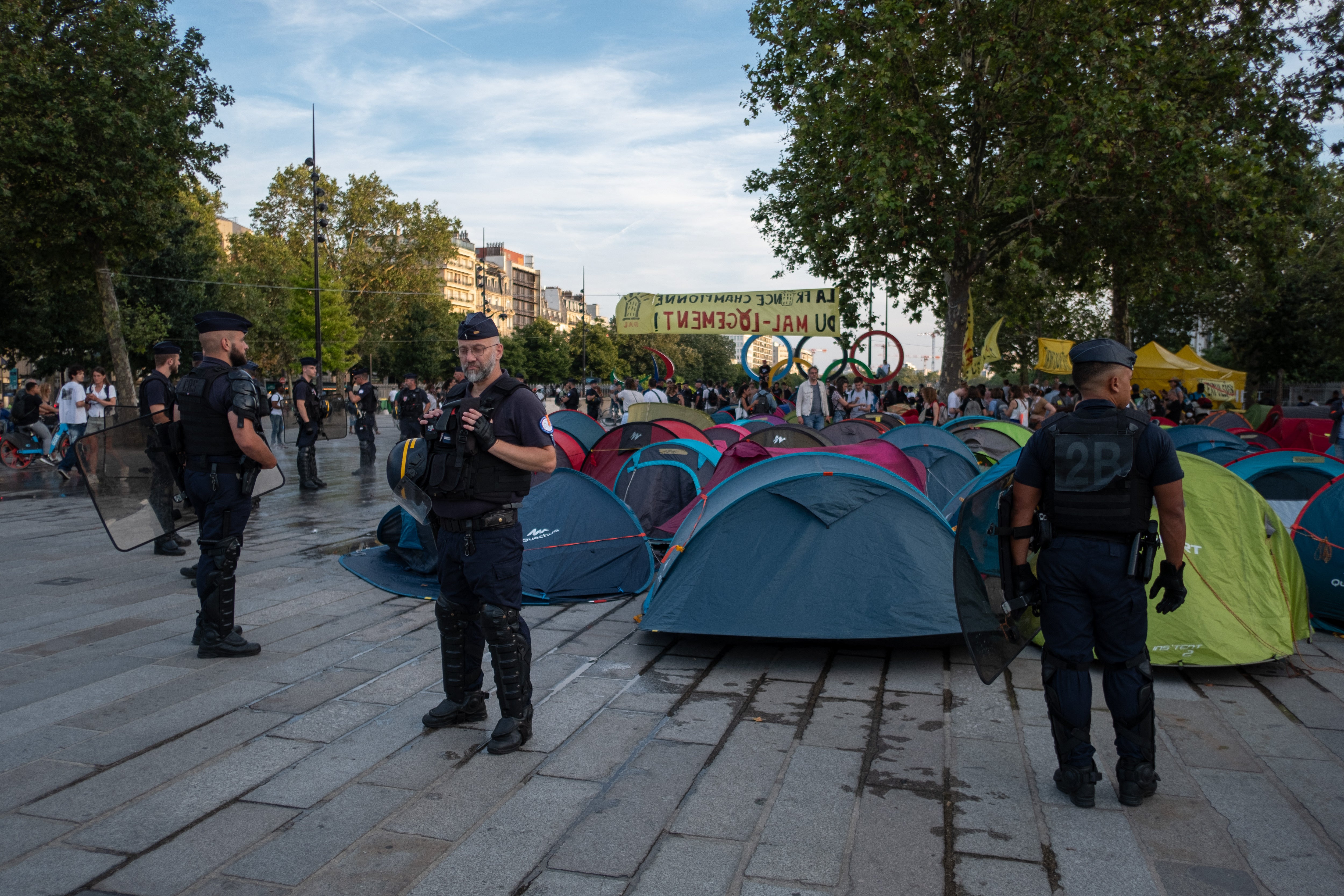 Police stand by a mass of tents in the centre of Paris