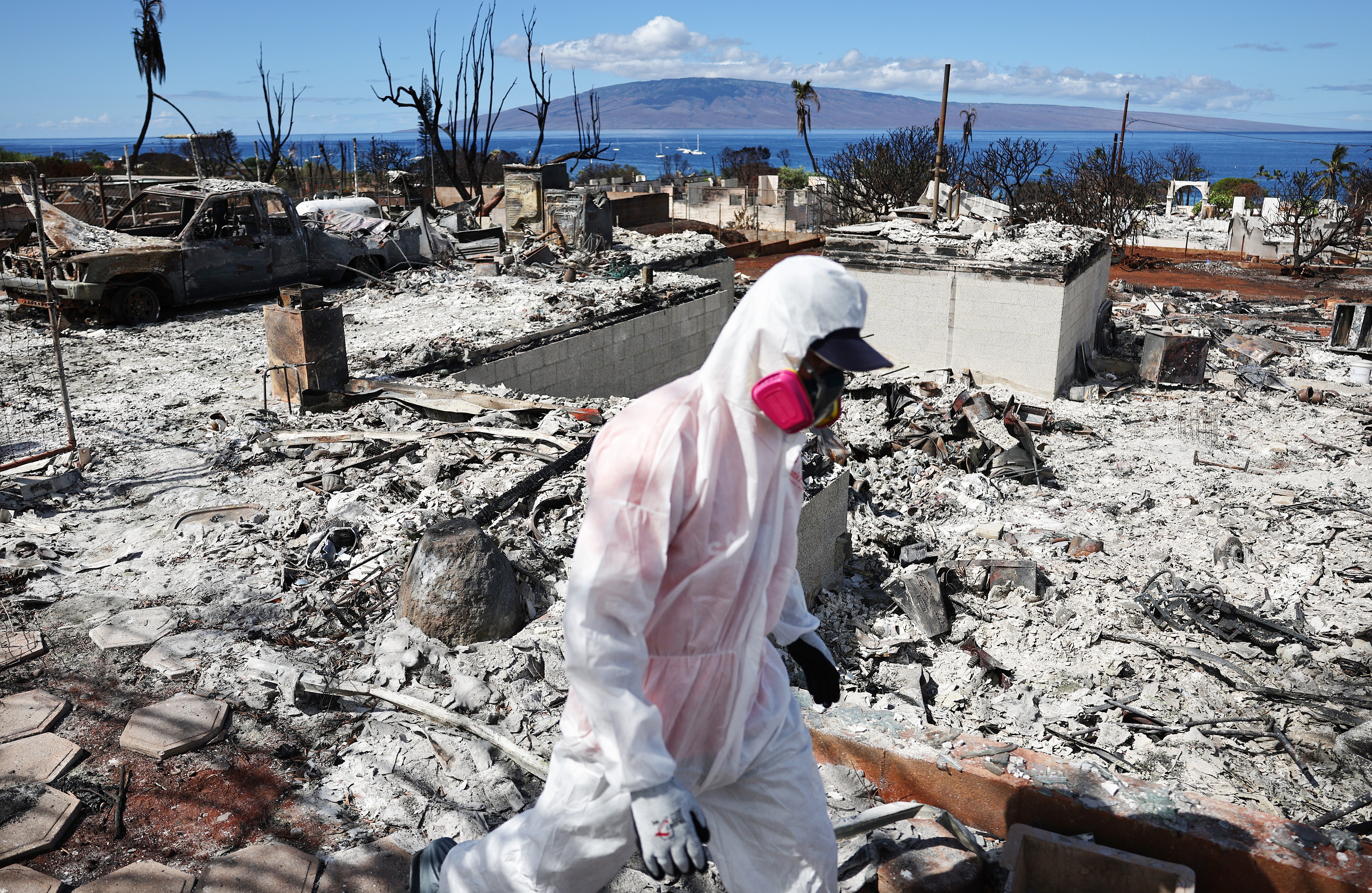 A volunteer from Samaritan's Purse helps a daughter search for family items in the rubble of her mother's home destroyed in the wildfires