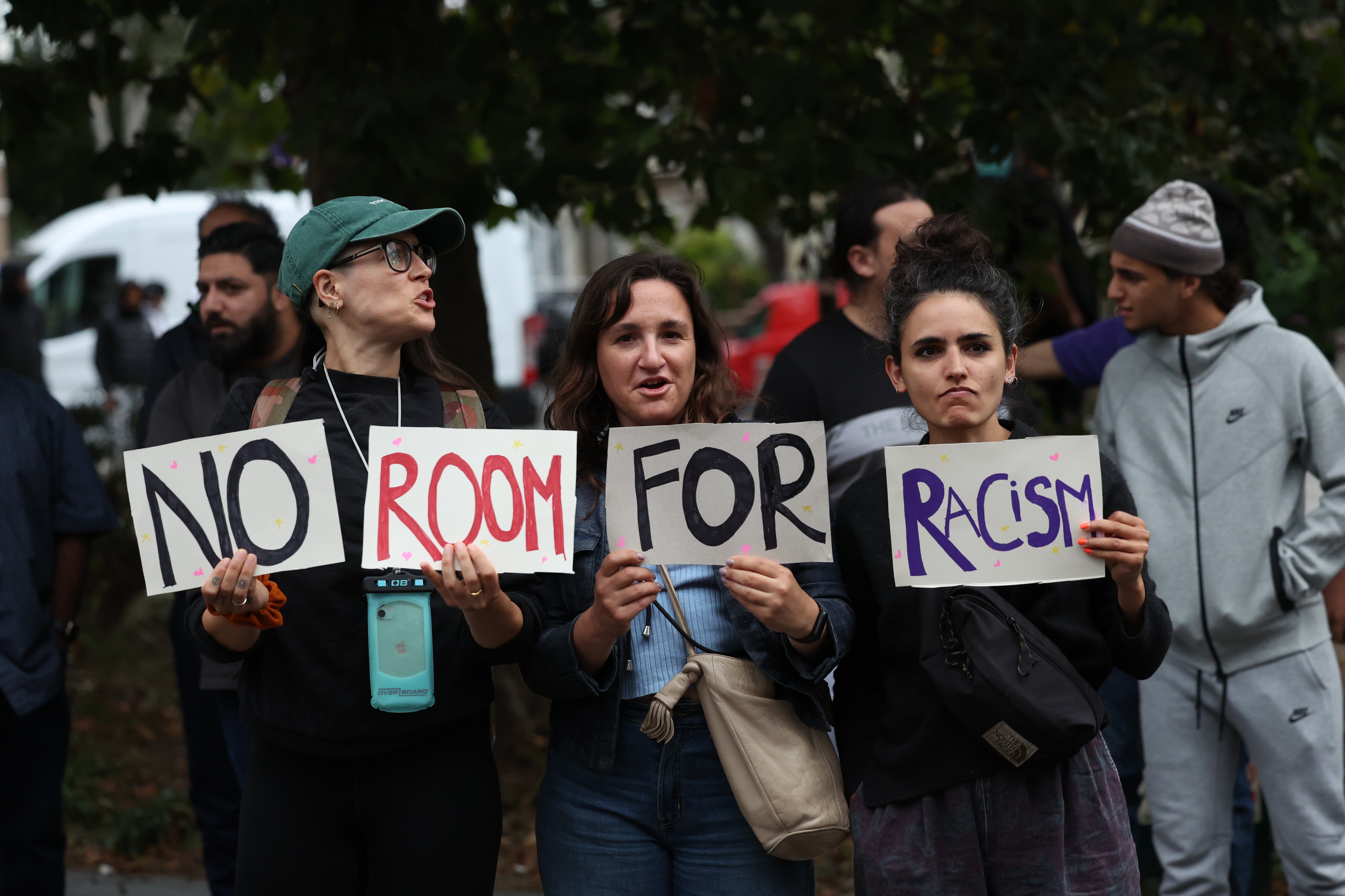 Three counter-demonstrators hold a ‘No room for racism’ banner ahead of a planned far-right gathering in Walthamstow